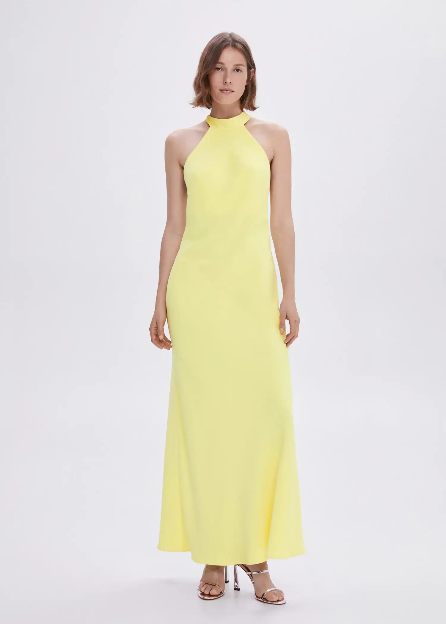 Mango Halter-neck open-back dress. a woman in a yellow dress standing in front of a white wall. 
