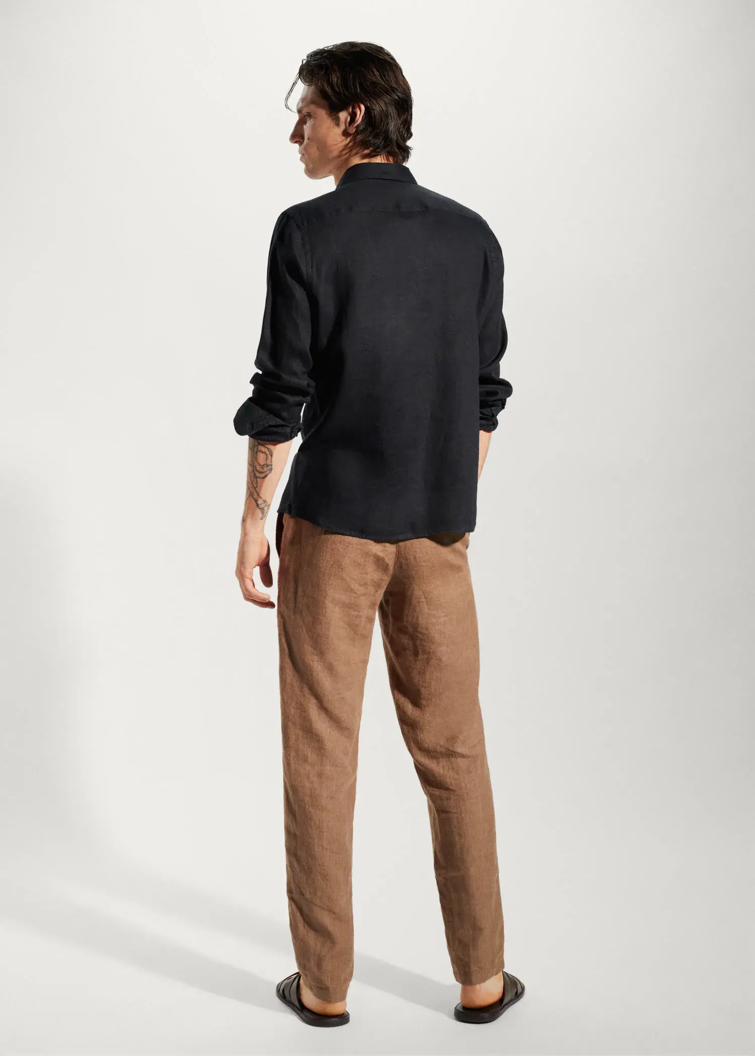Mango 100% linen slim-fit shirt. a man wearing a black shirt and brown pants. 