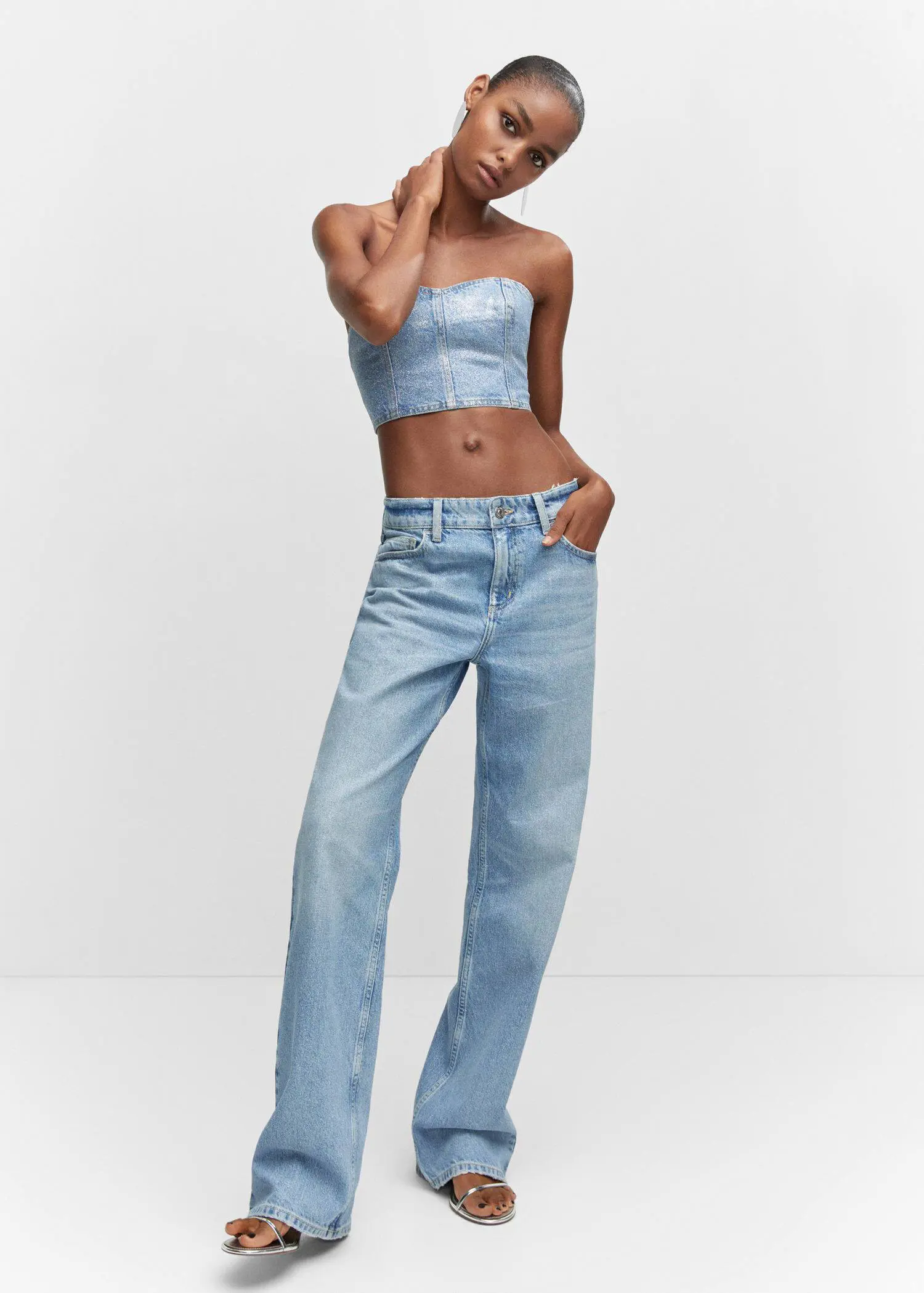 Mango Denim glitter corset top. a woman in a strapless top and high-waisted jeans 