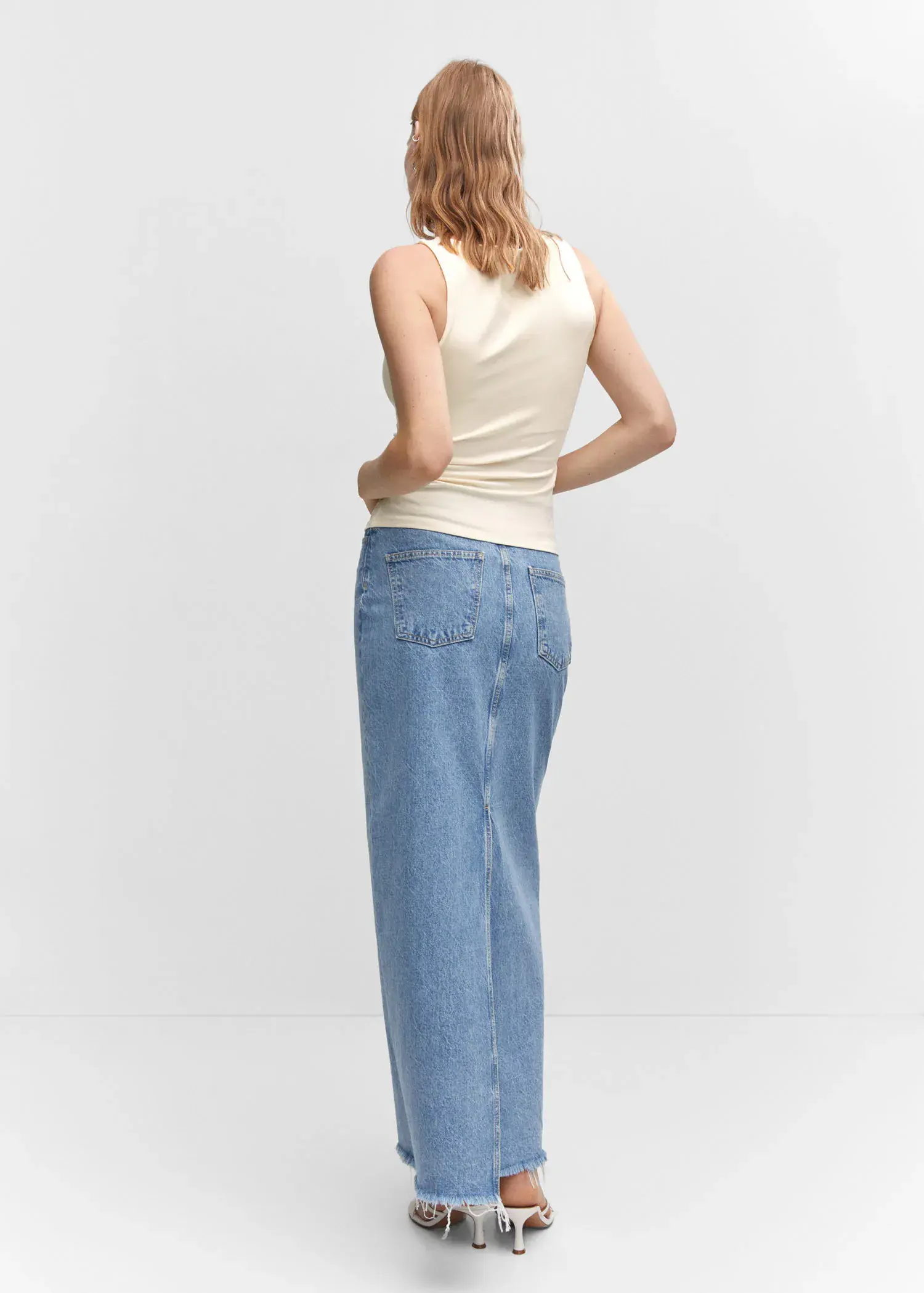 Mango Open elastic top. a woman in a white shirt and blue jeans. 