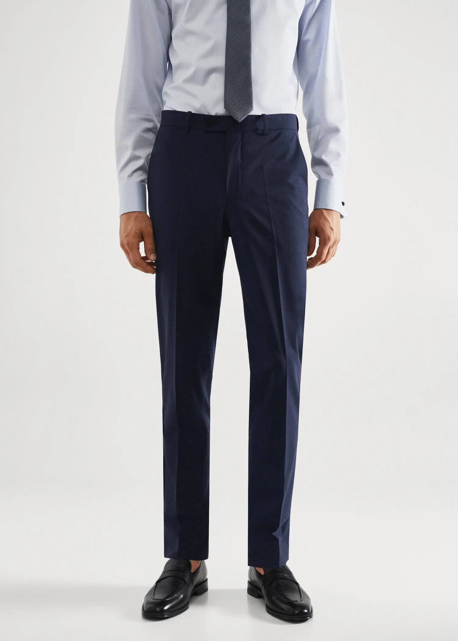 Mango Wool slim-fit check suit trousers. a man wearing a suit and tie standing in front of a white wall. 