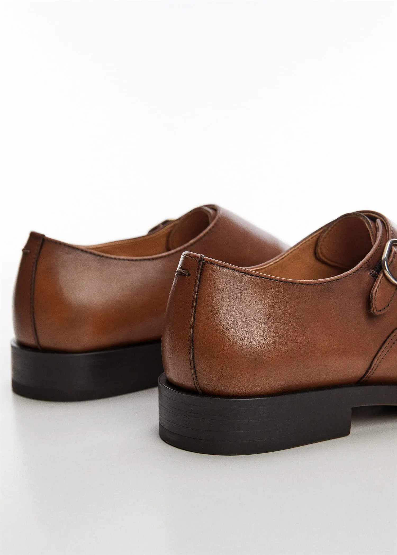 Mango Monk shoes with leather buckle. a close up of a pair of shoes on a table 