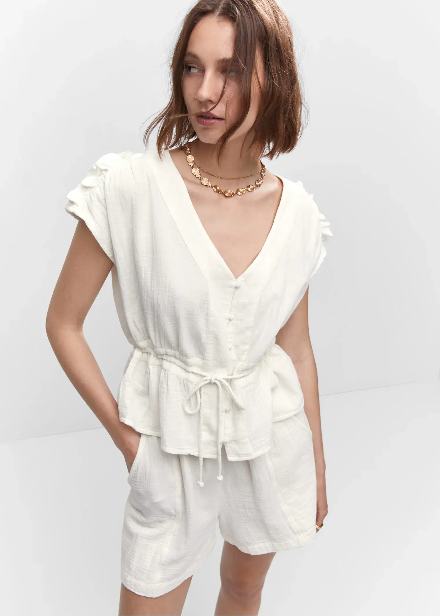 Mango Bow textured blouse. a woman wearing a white outfit and a gold necklace. 