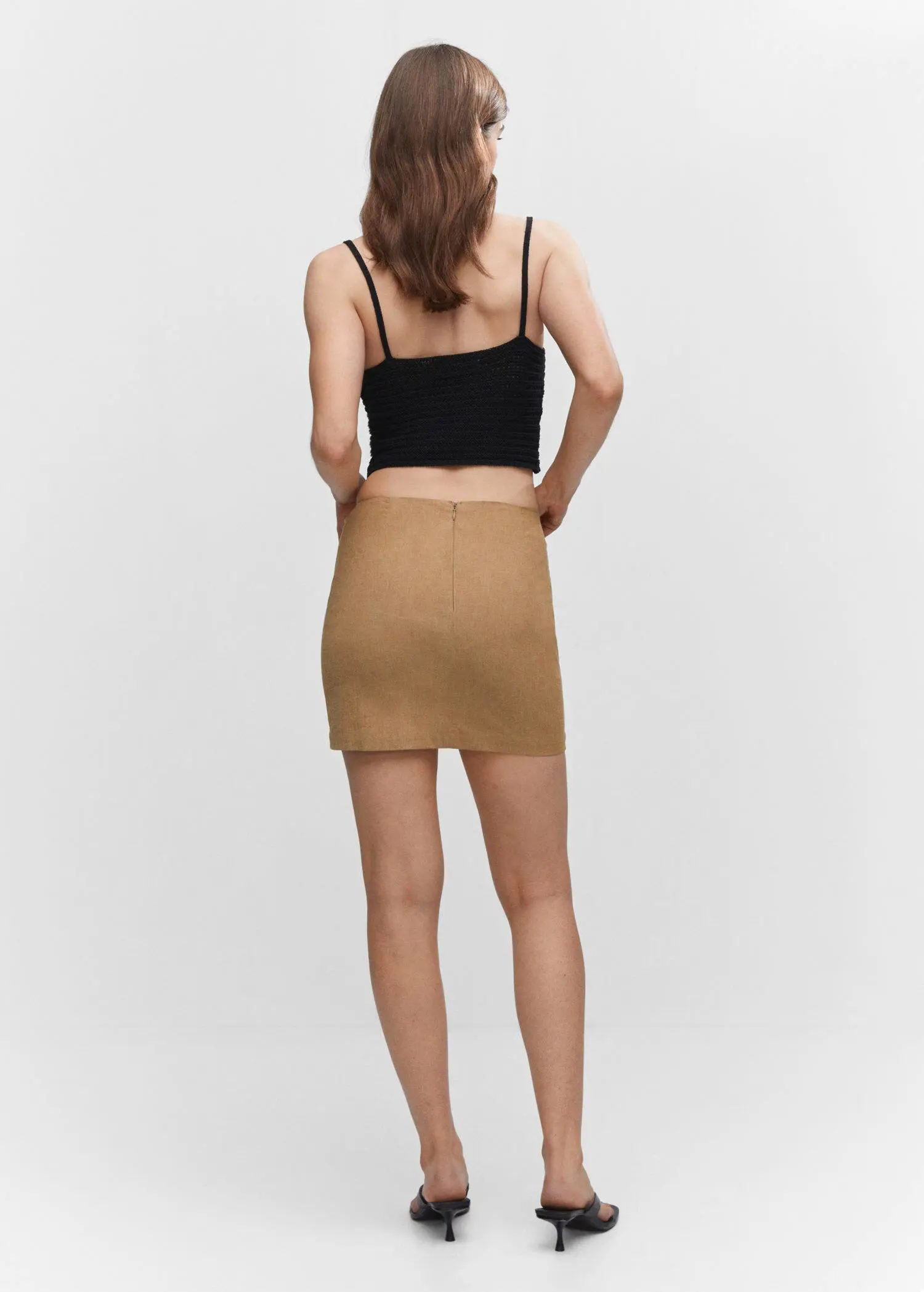 Mango Ruched details skirt. a woman in a black top and tan skirt. 