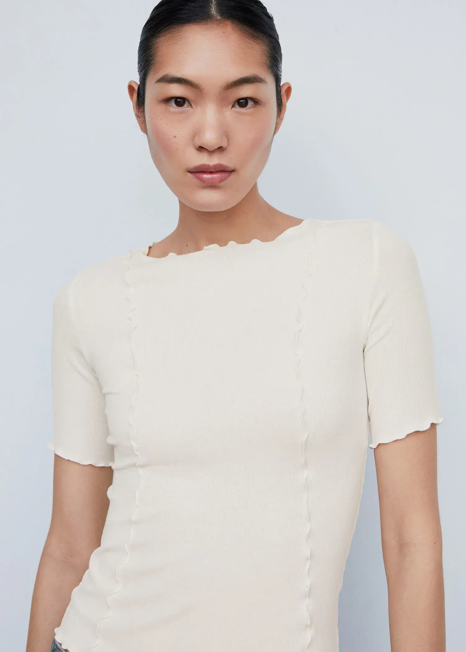 Mango Decorative seam T-shirt. a woman wearing a white top with short sleeves. 