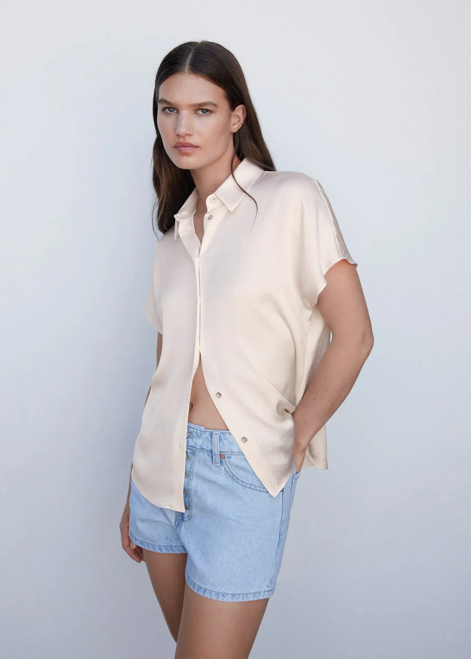 Mango Short-sleeve button-down shirt. a woman wearing a white shirt and blue shorts. 