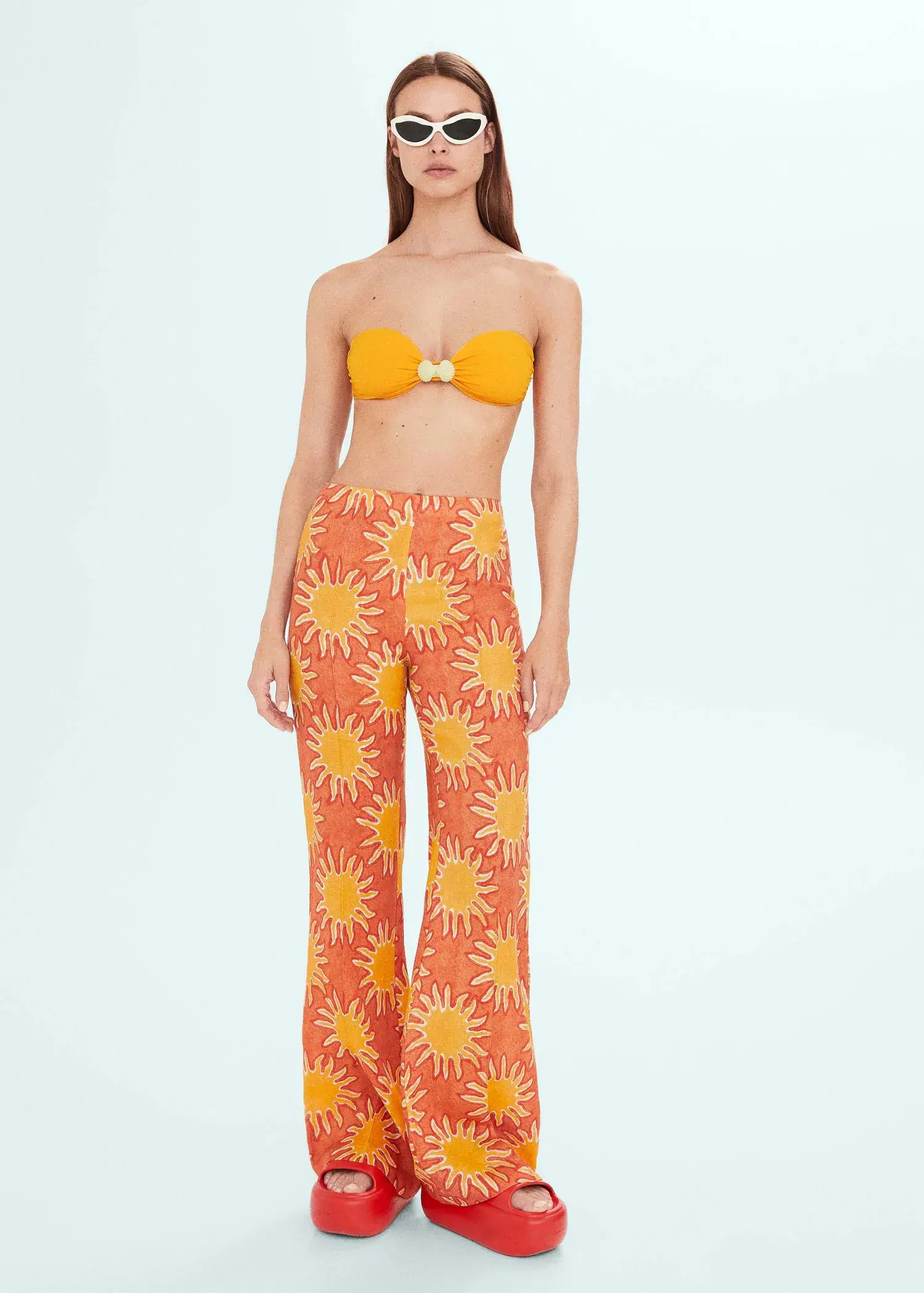 Mango Printed linen wideleg trousers. a woman in a yellow and orange bikini top. 