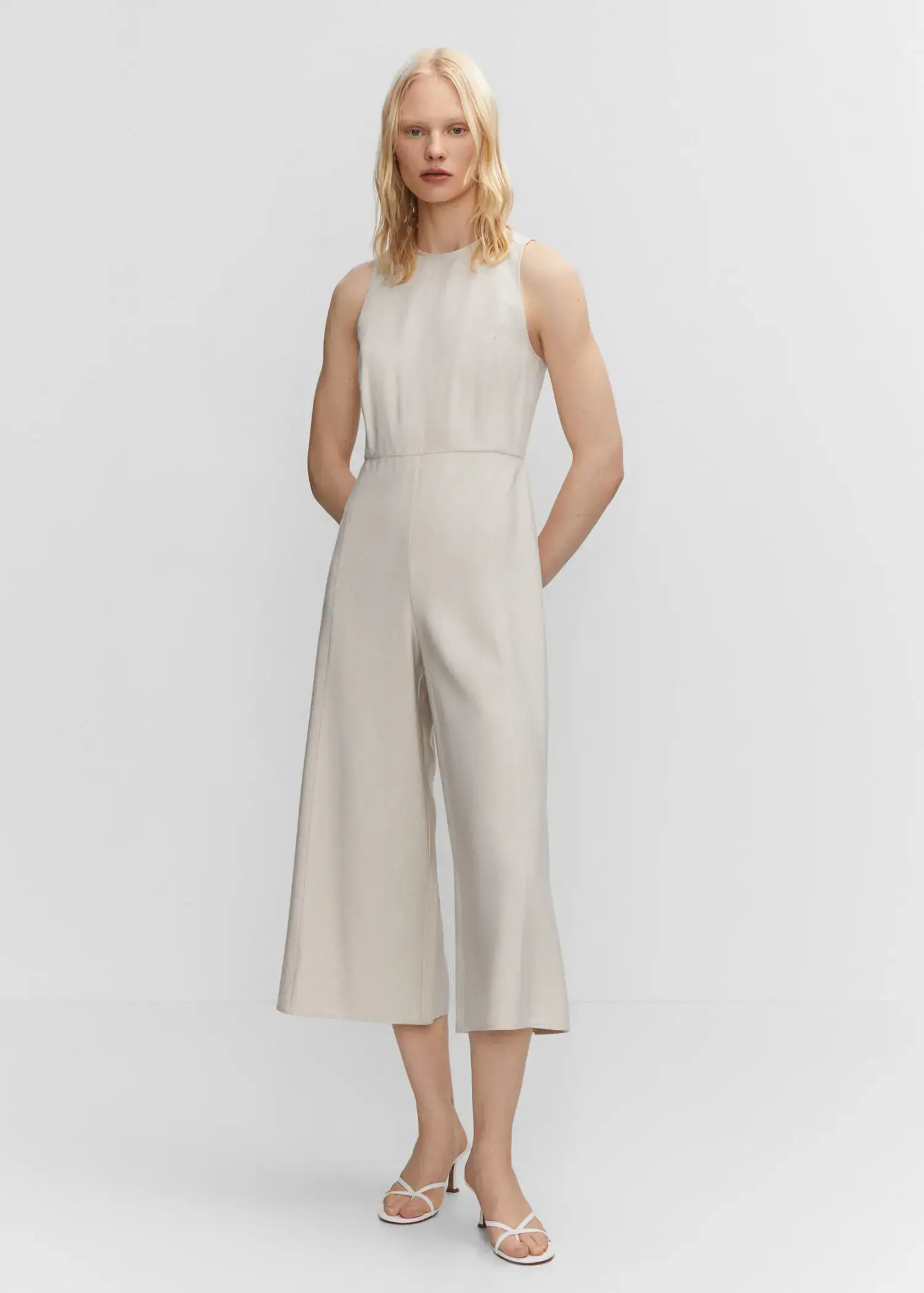 Mango Cropped jumpsuit with straps. a woman wearing a white jumpsuit standing in front of a white wall. 