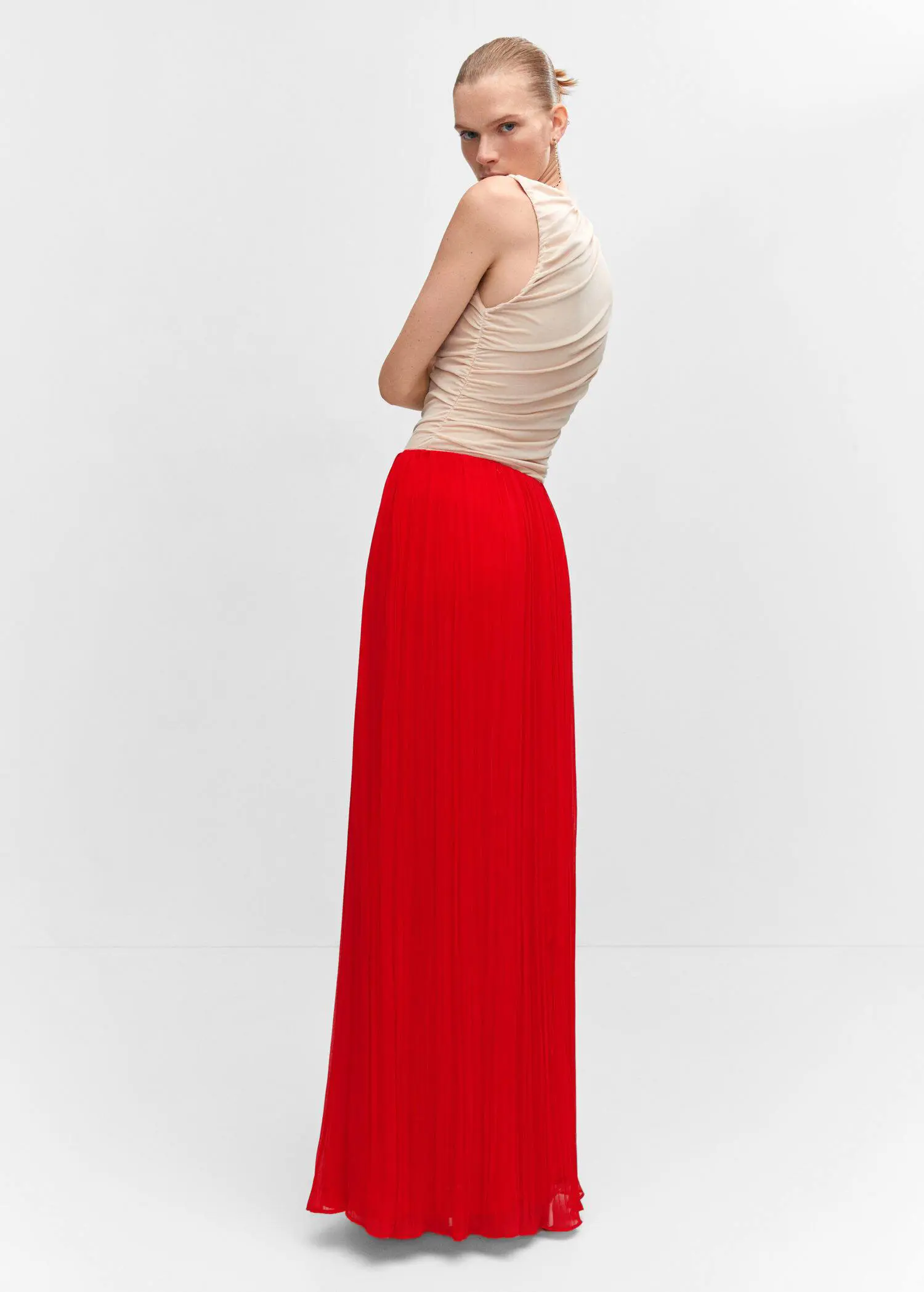 Mango Pleated long skirt. a woman wearing a long red skirt and a beige top. 