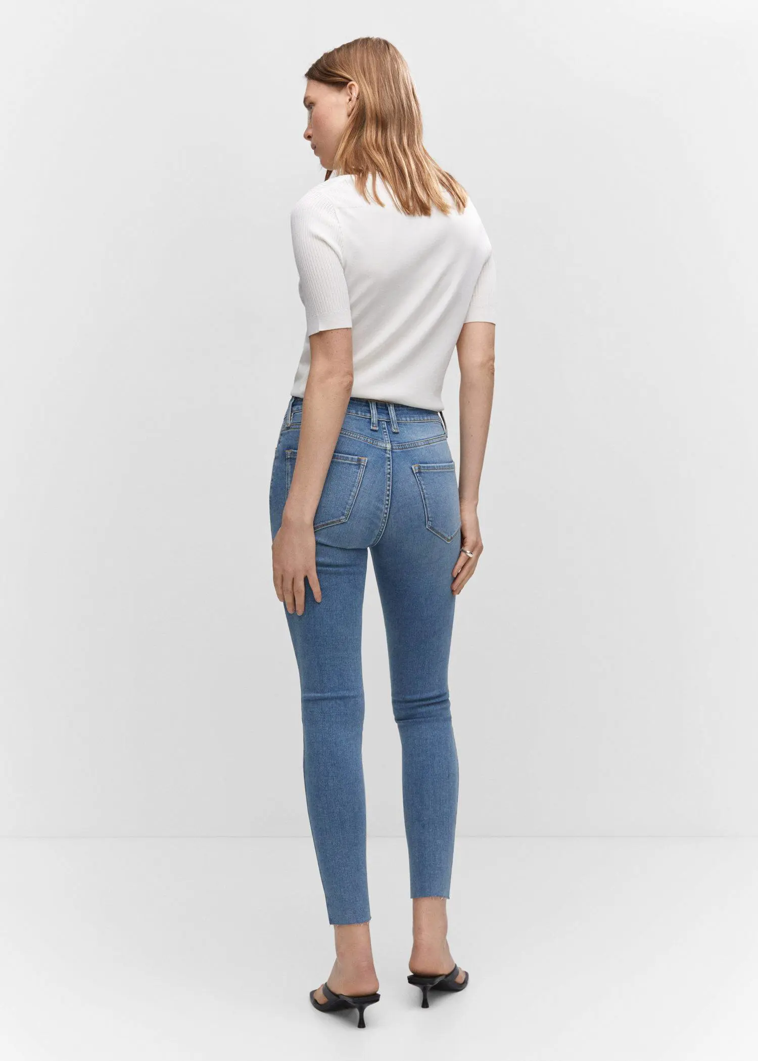 Mango Skinny cropped jeans. a woman is standing in front of a wall. 