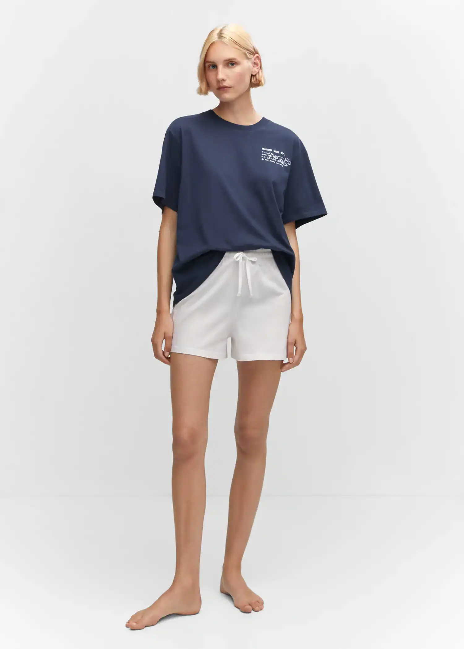 Mango Cotton shorts with elastic waist. a woman wearing white shorts and a t-shirt. 