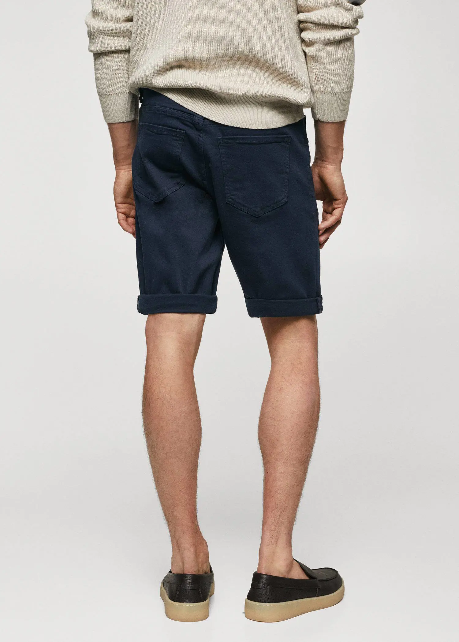 Mango Slim-fit denim bermuda shorts. a man wearing a pair of navy blue shorts. 