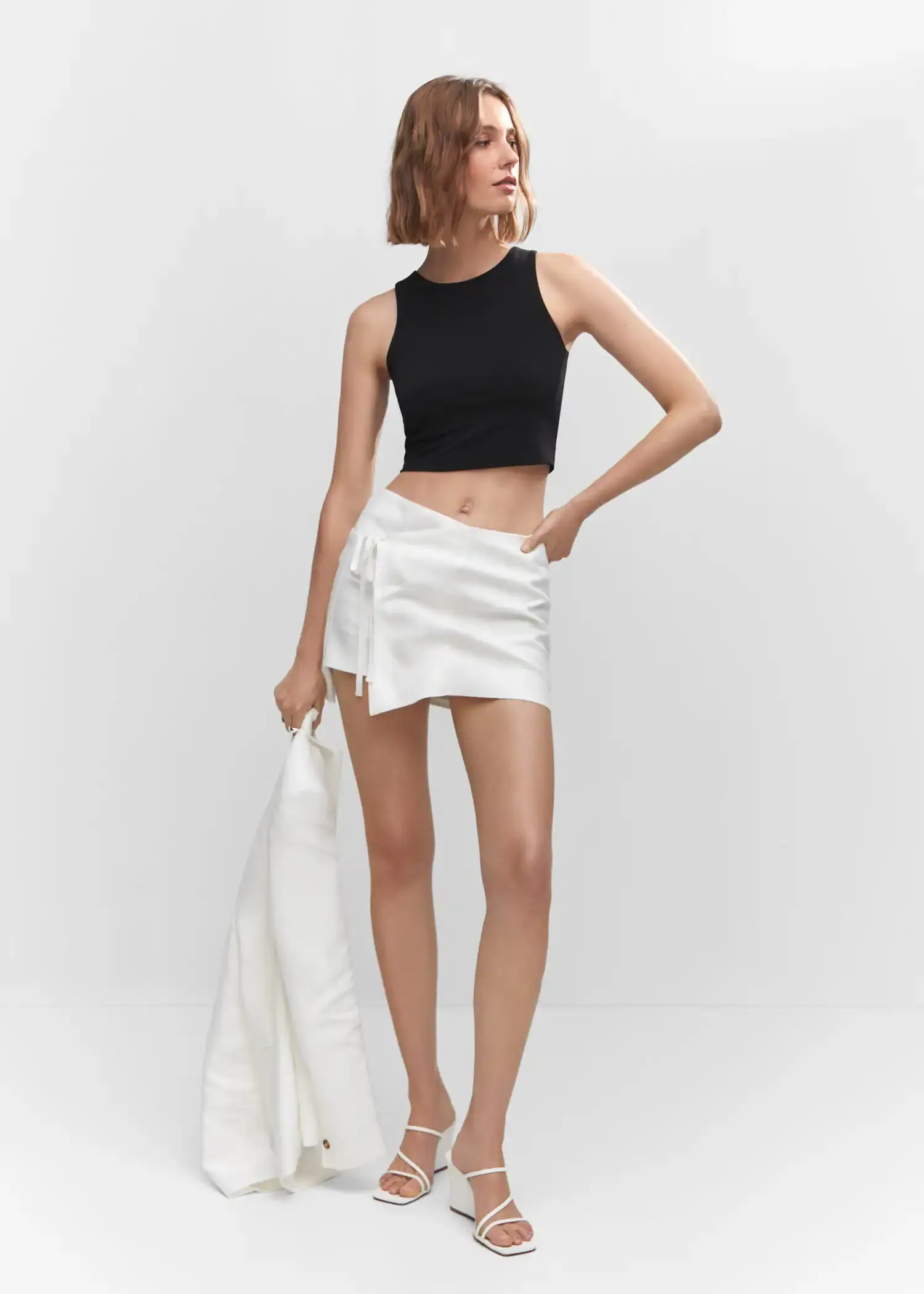 Mango Crop top halter neck. a woman wearing a black top and white skirt. 
