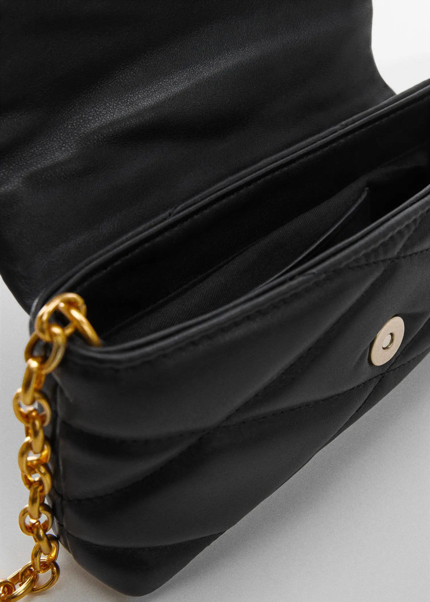 Mango Quilted chain bag. a close-up of the inside of a black purse. 