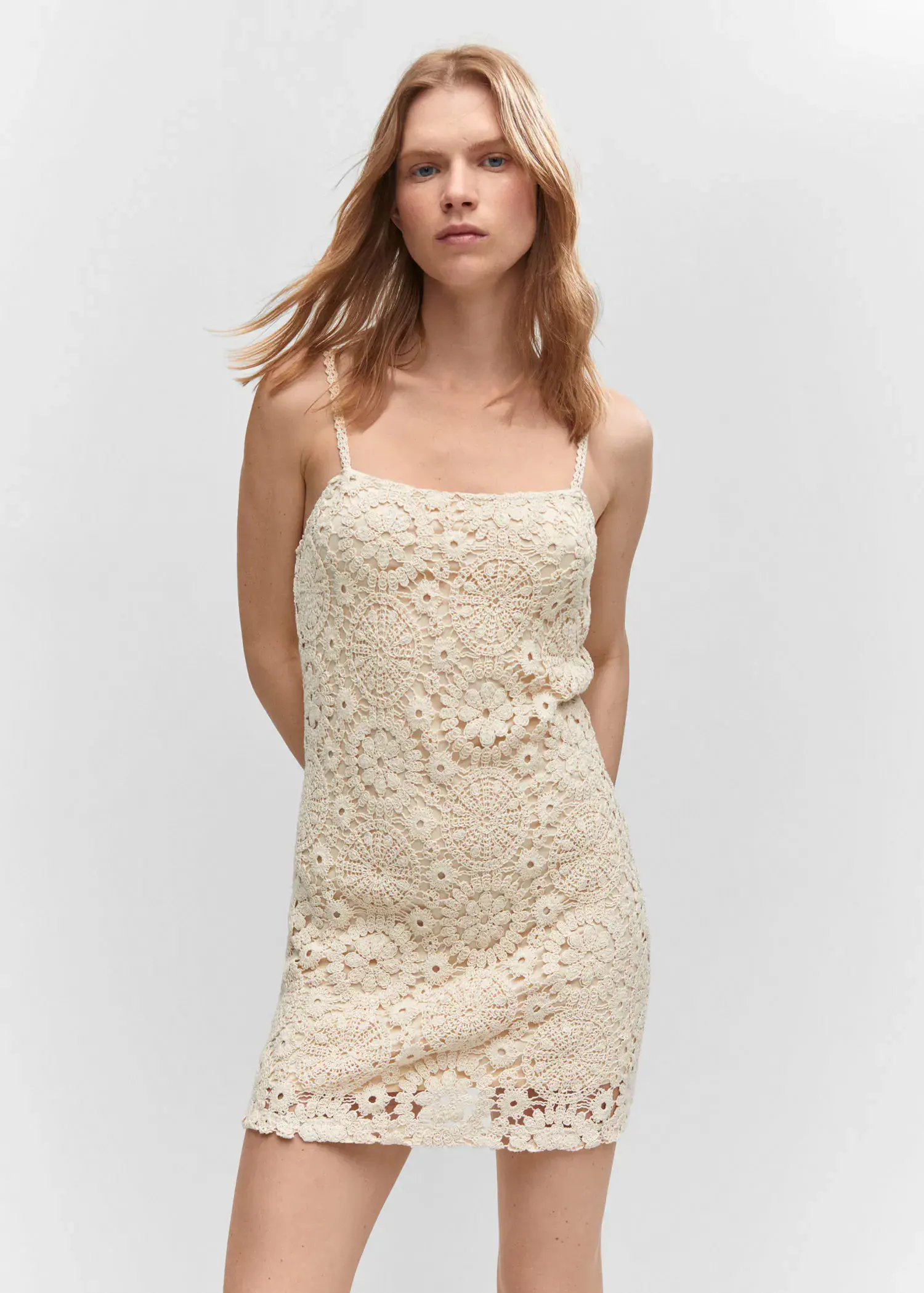 Mango Crochet short dress. a woman wearing a white dress standing in front of a white wall. 