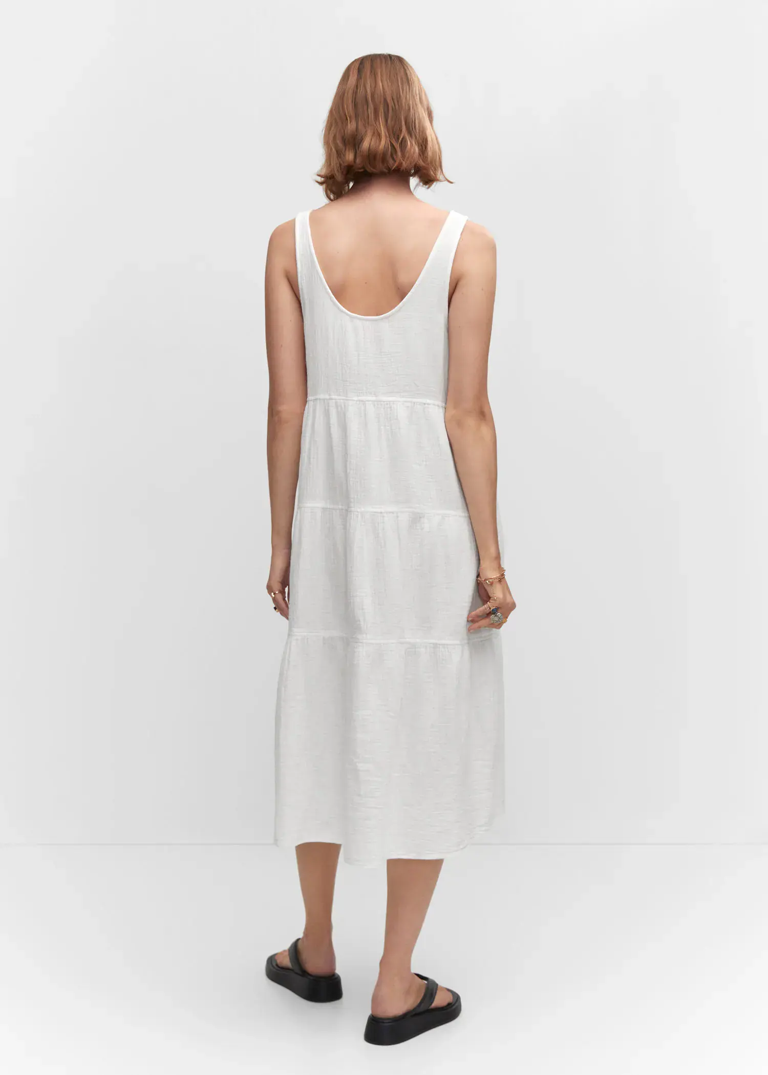 Mango Flared cotton dress. a person wearing a white dress standing in a room. 