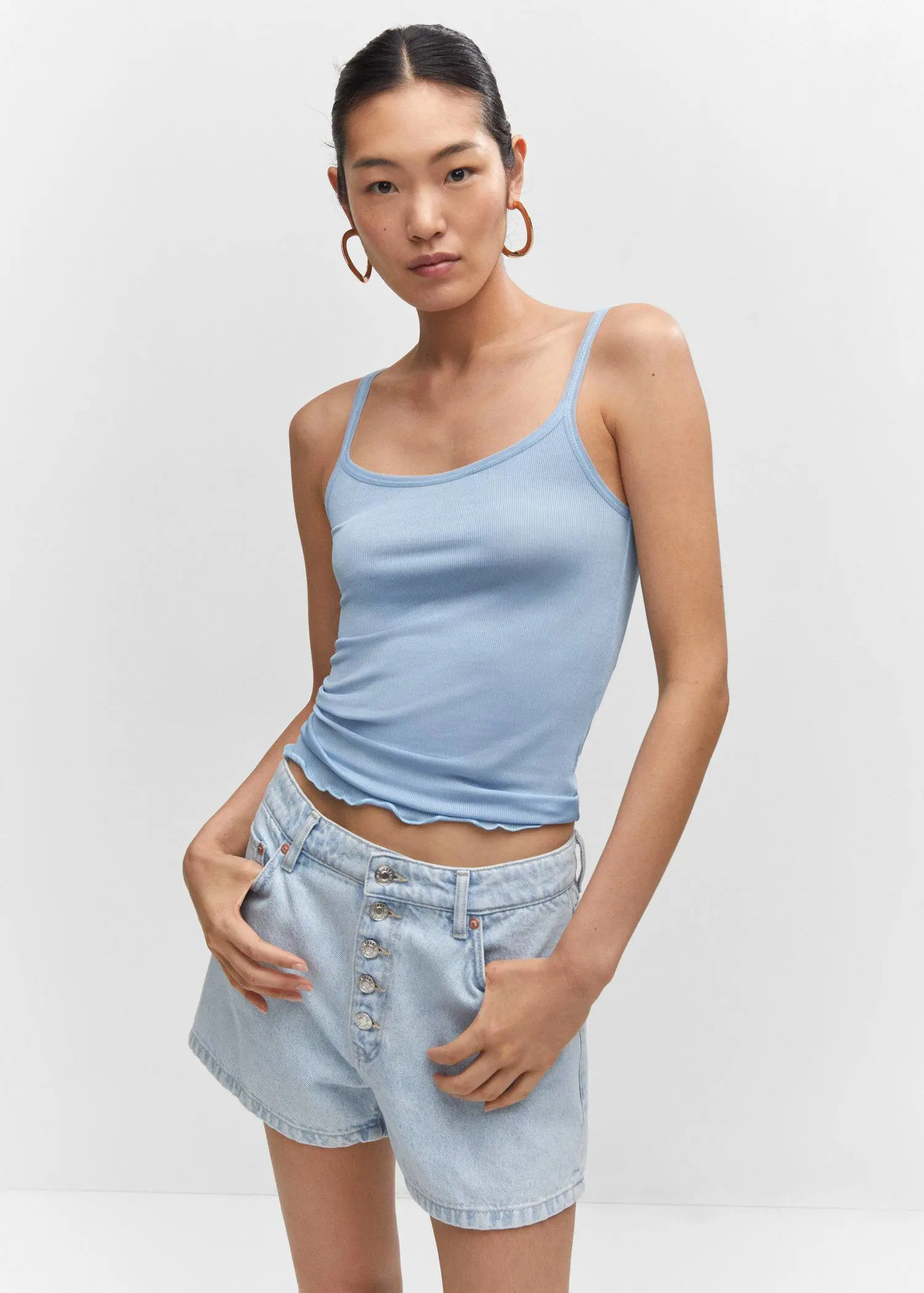 Mango Ribbed strap top. a woman wearing a blue tank top and a pair of denim shorts. 