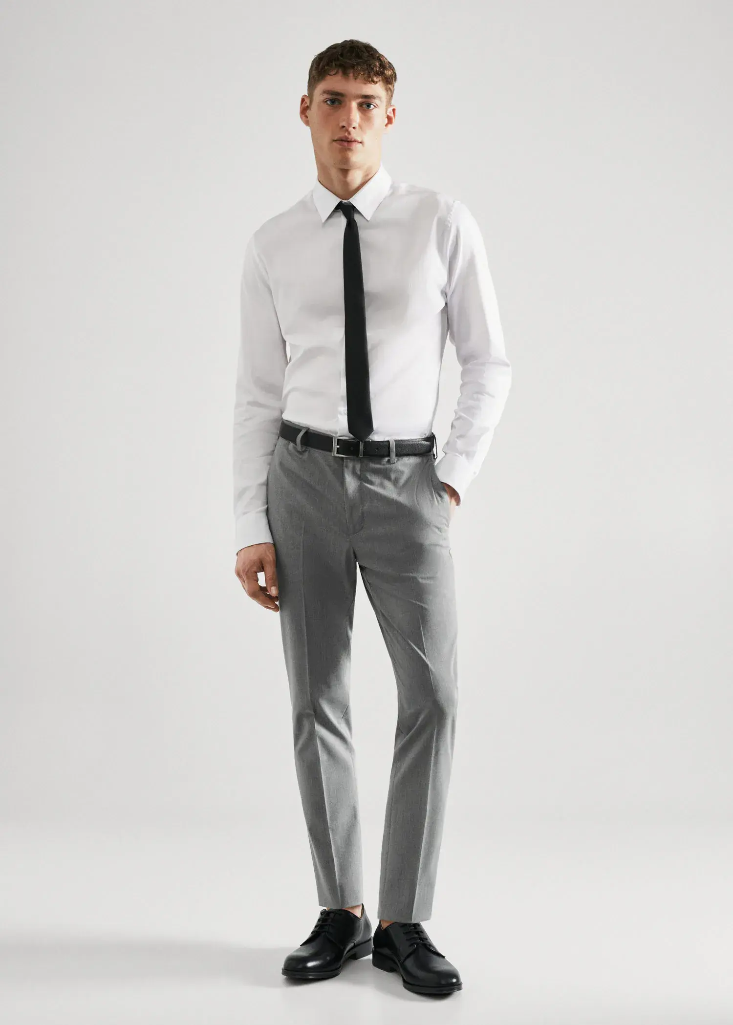 Mango Stretch fabric super slim-fit suit trousers. a man in a white shirt and black tie. 