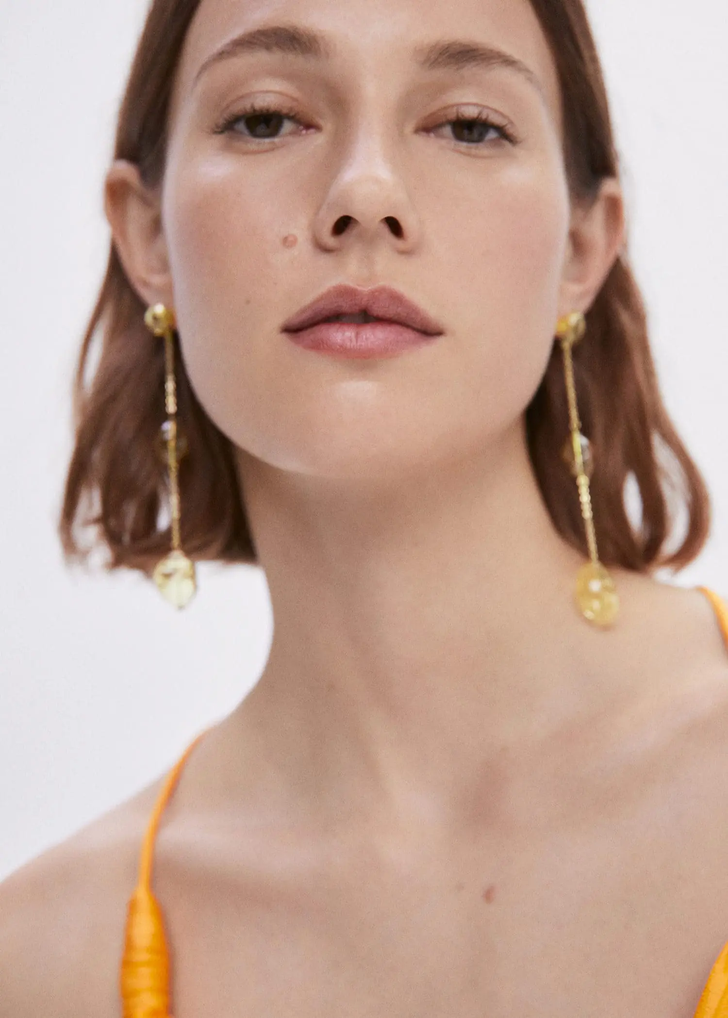 Mango Crystal thread earrings. a close up of a person wearing earrings 