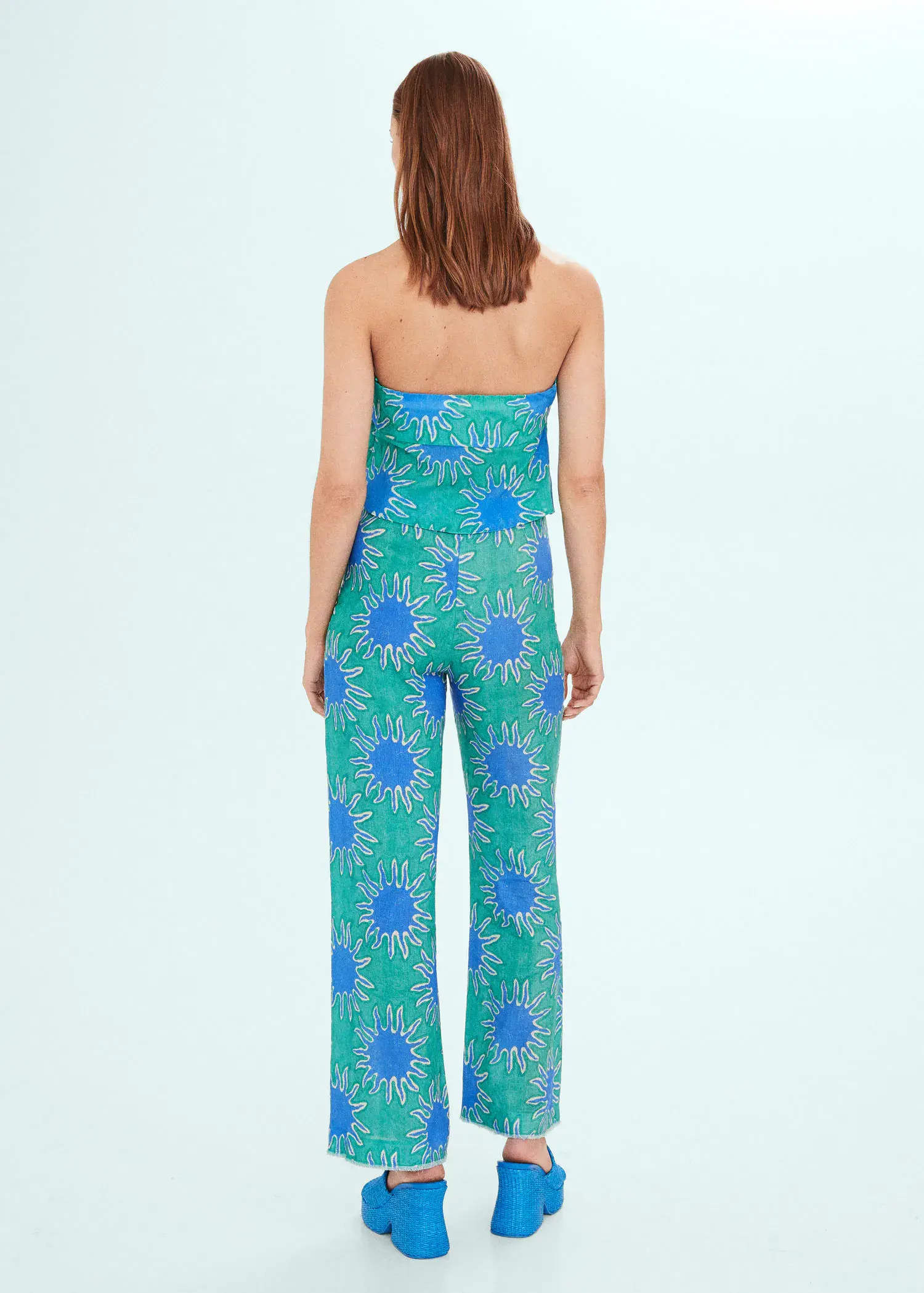 Mango Bandeau top with knot print. a woman wearing a green and blue floral jumpsuit. 