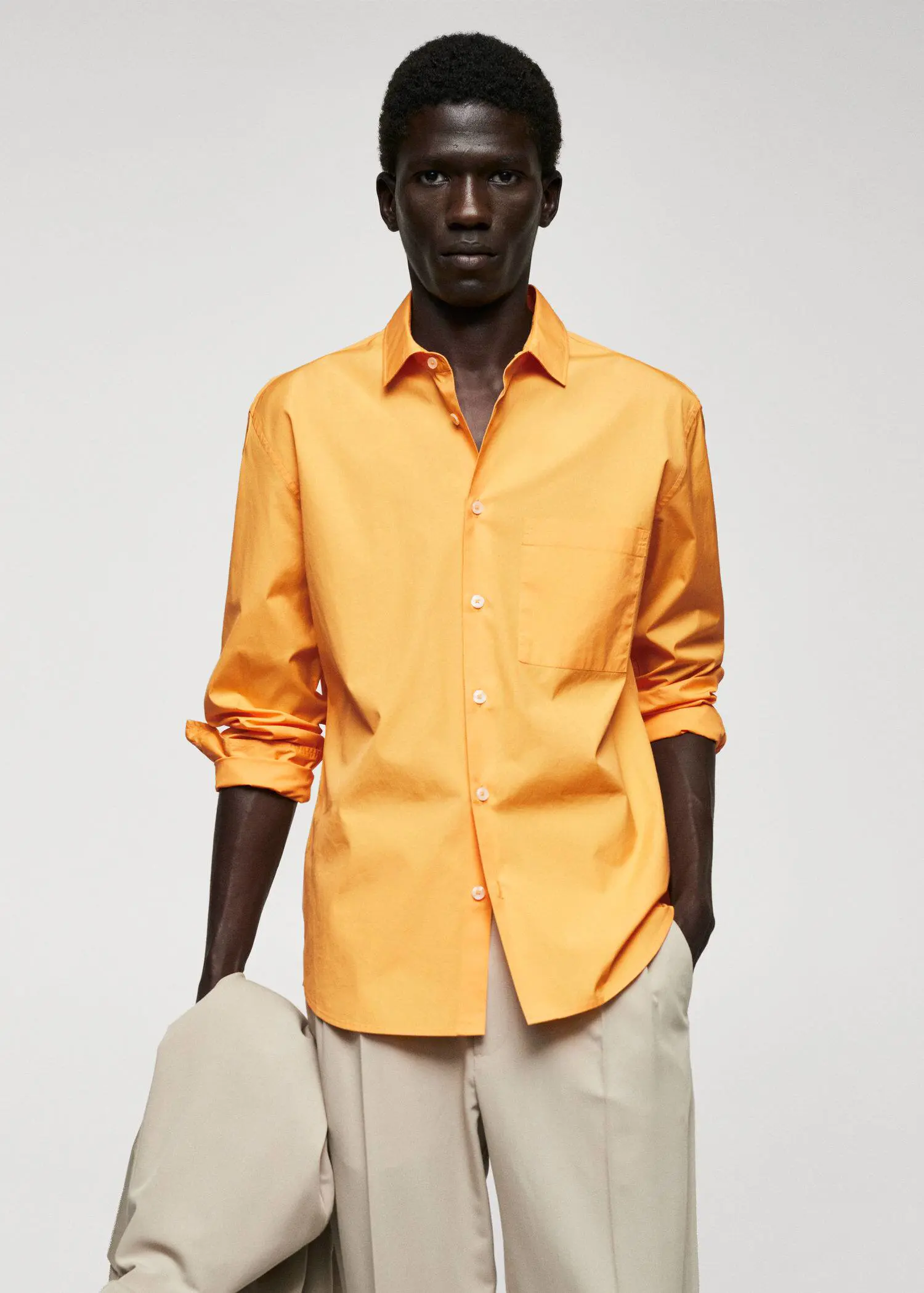 Mango 100% cotton pocket shirt. a man wearing a yellow shirt and beige pants. 