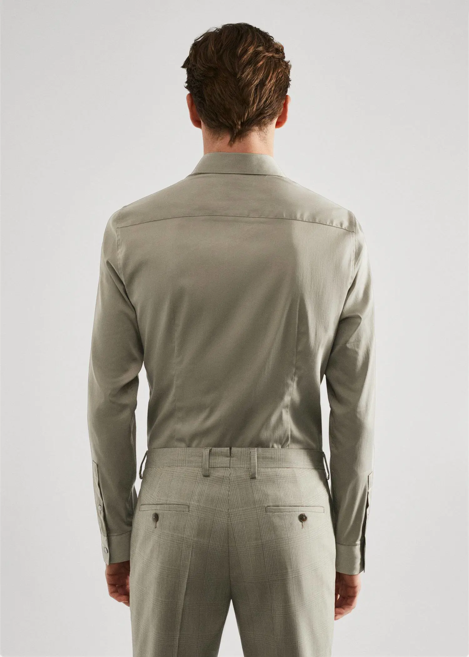 Mango Super slim-fit poplin suit shirt. a man in a tan suit standing in front of a white wall. 