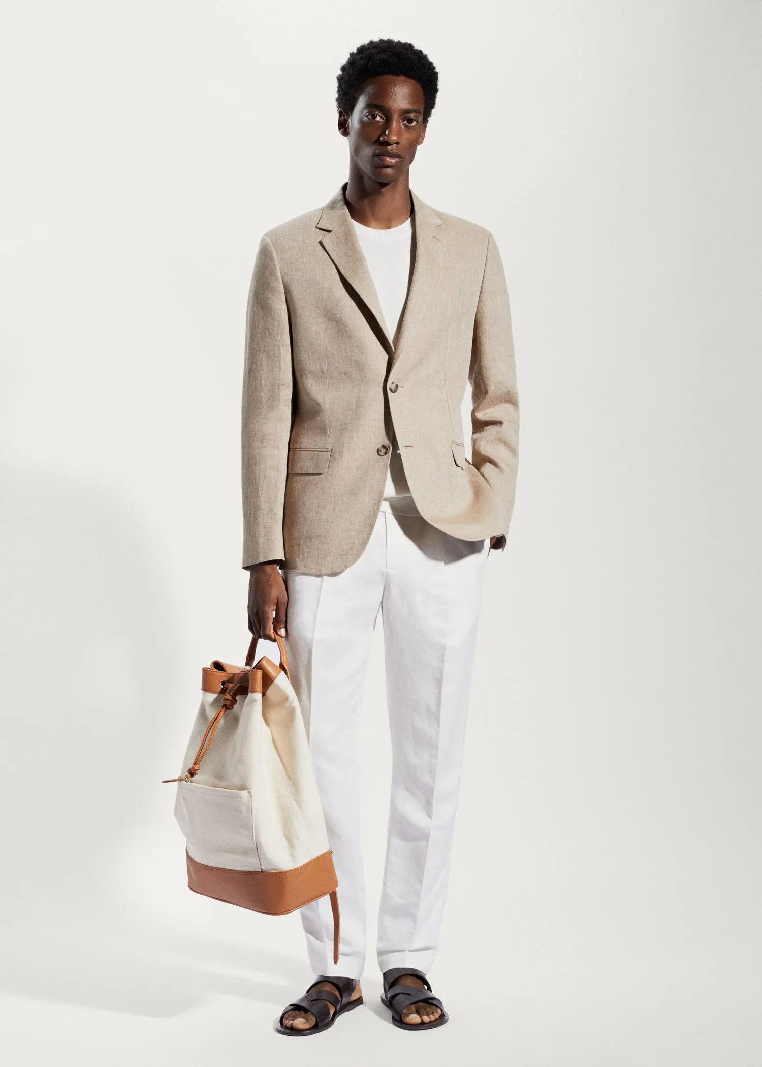 Mango 100% linen slim fit blazer. a man in a suit holding a bag. 