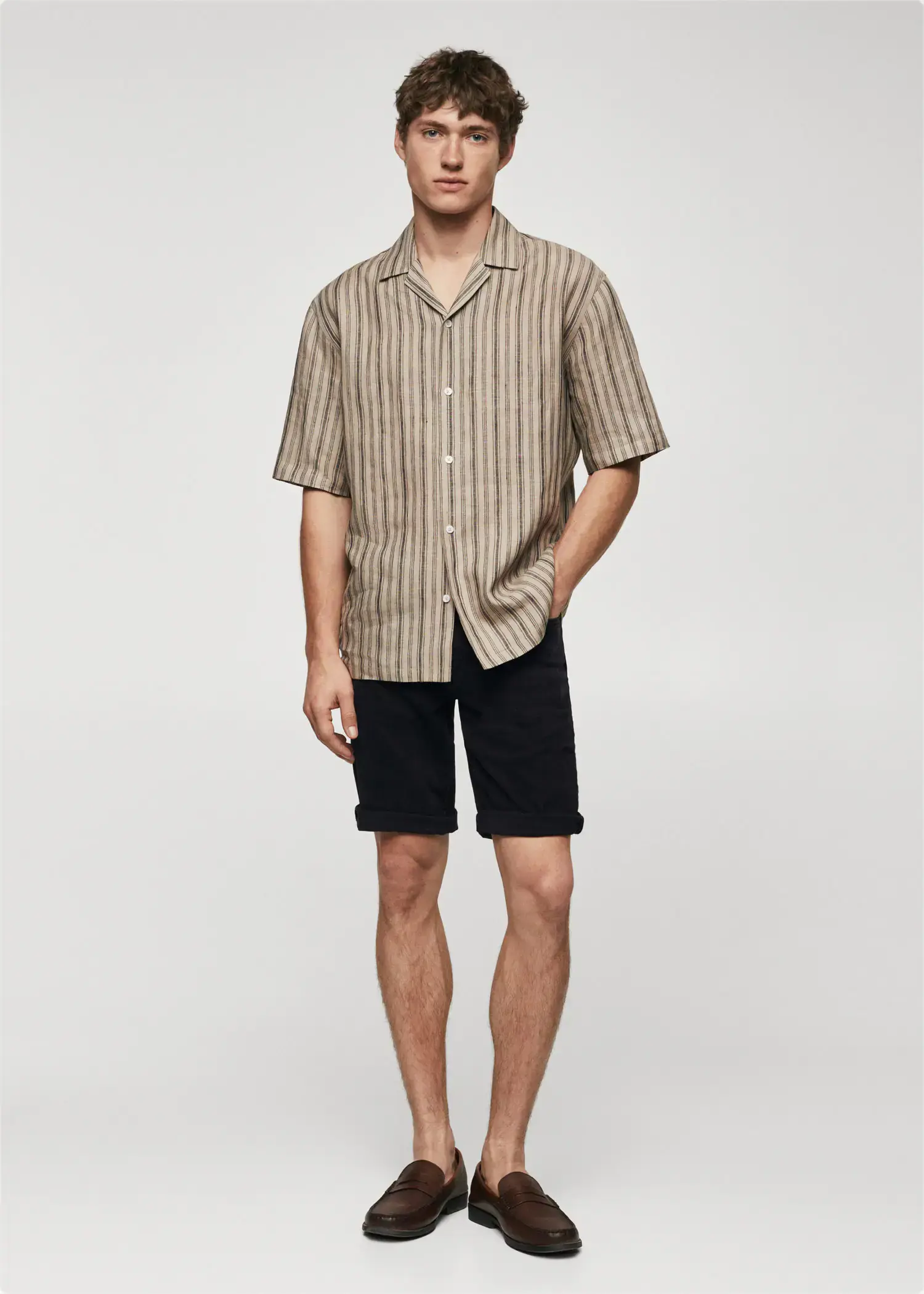 Mango Slim-fit denim bermuda shorts. a young man wearing black shorts and a striped shirt. 