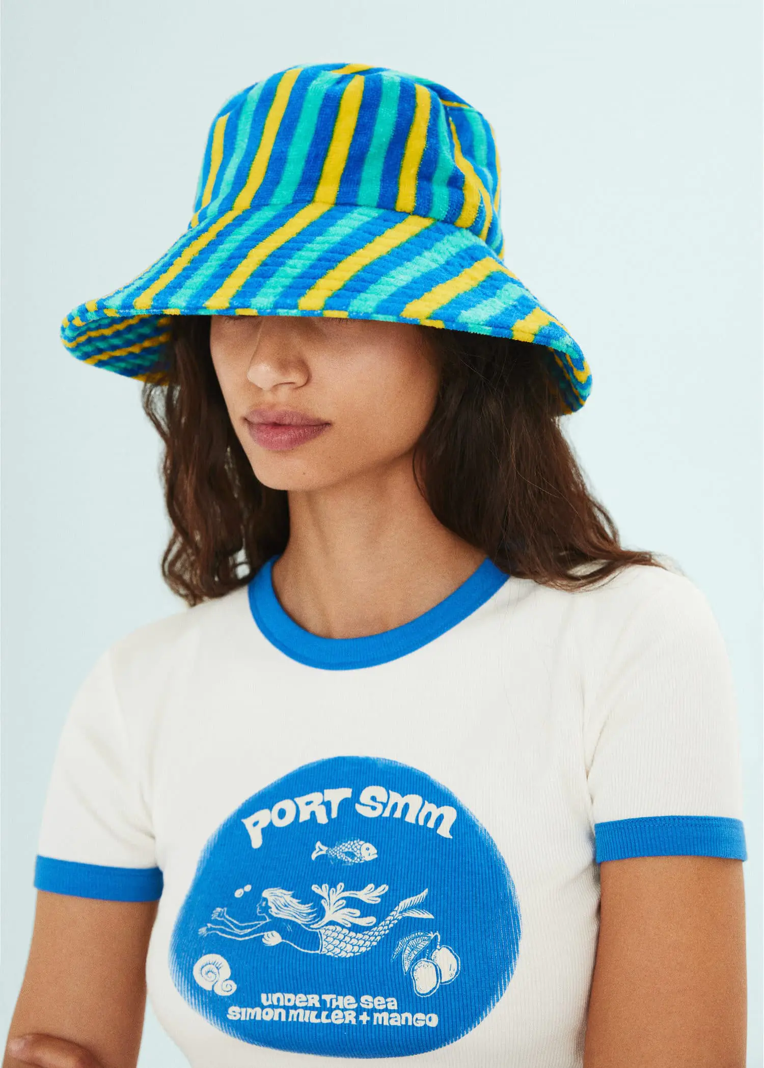 Mango Striped terry cloth bucket hat. a woman wearing a blue and yellow hat. 
