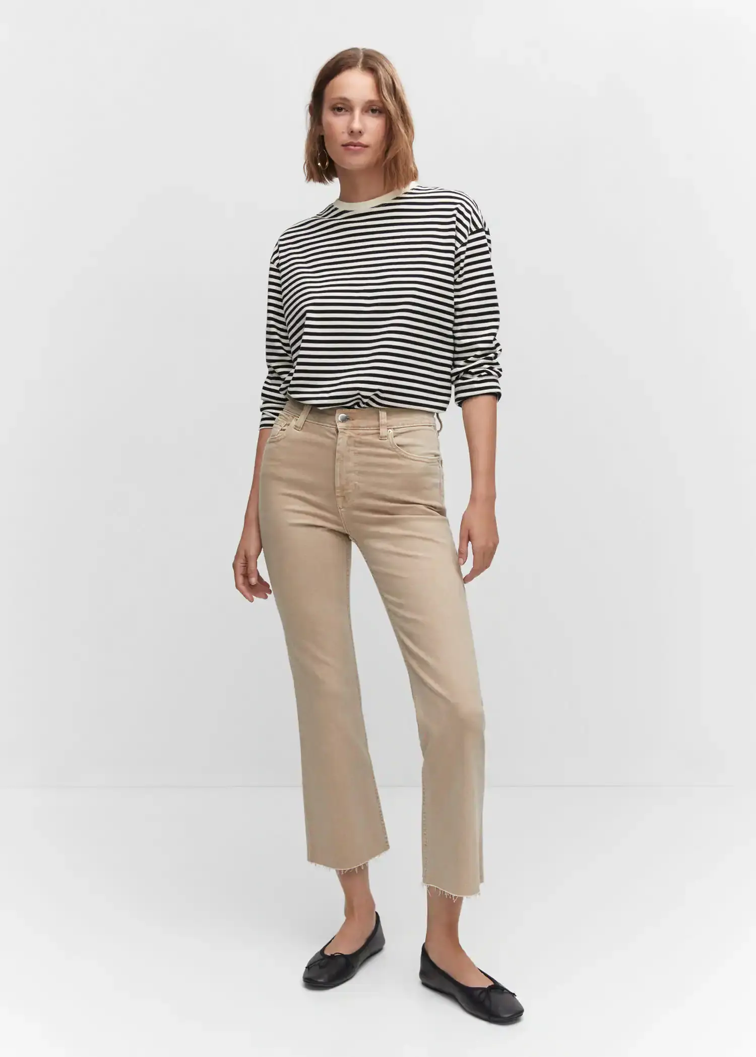 Mango Crop flared jeans. a woman wearing a striped shirt and beige pants. 