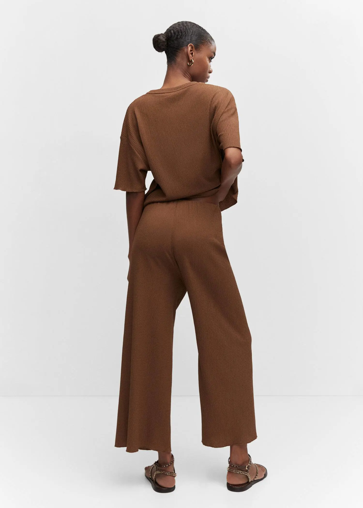 Mango Oversized textured t-shirt. a person standing in a room wearing a brown outfit. 