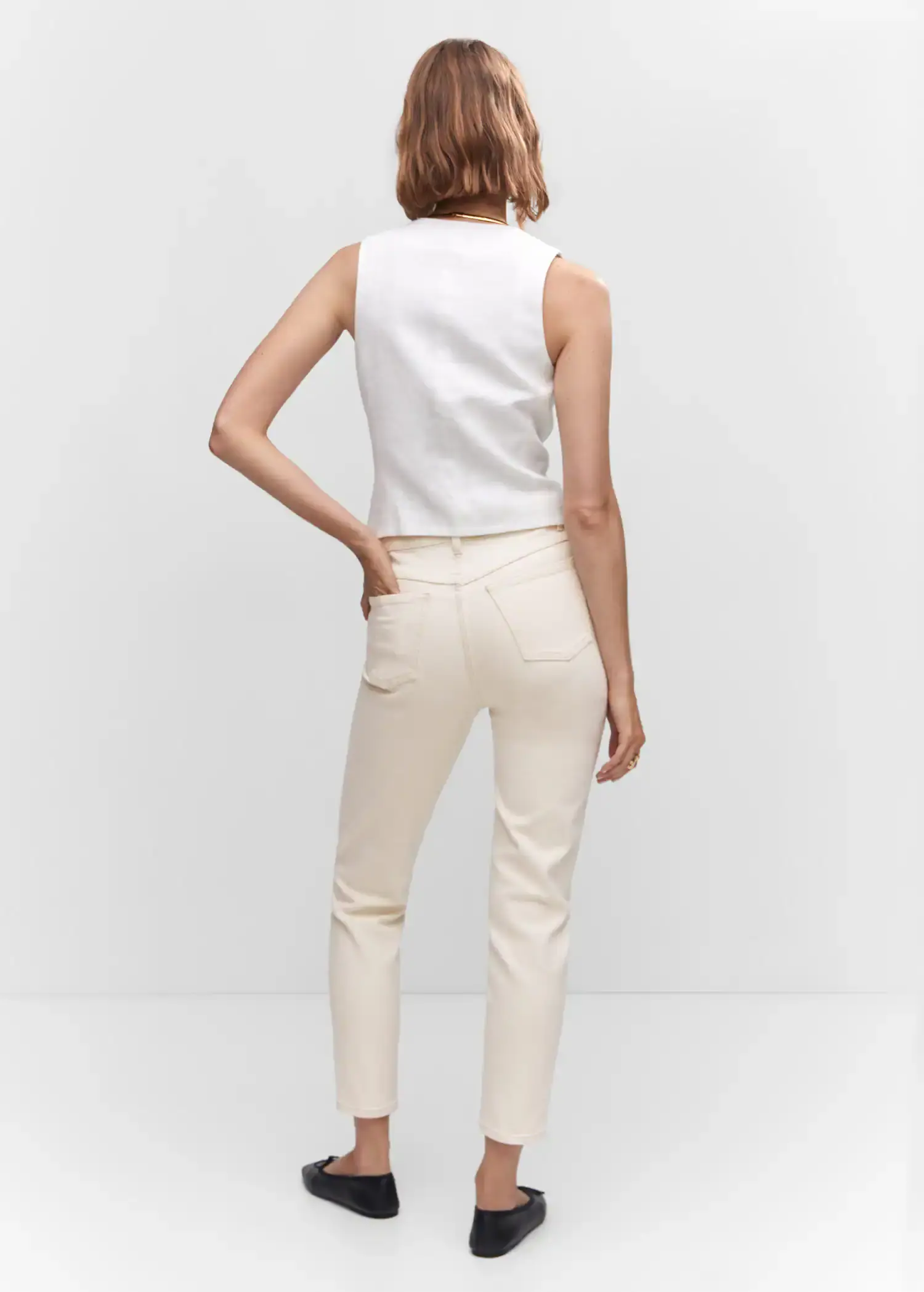 Mango Mom comfort high-rise jeans. a woman is standing with her hands on her hips. 