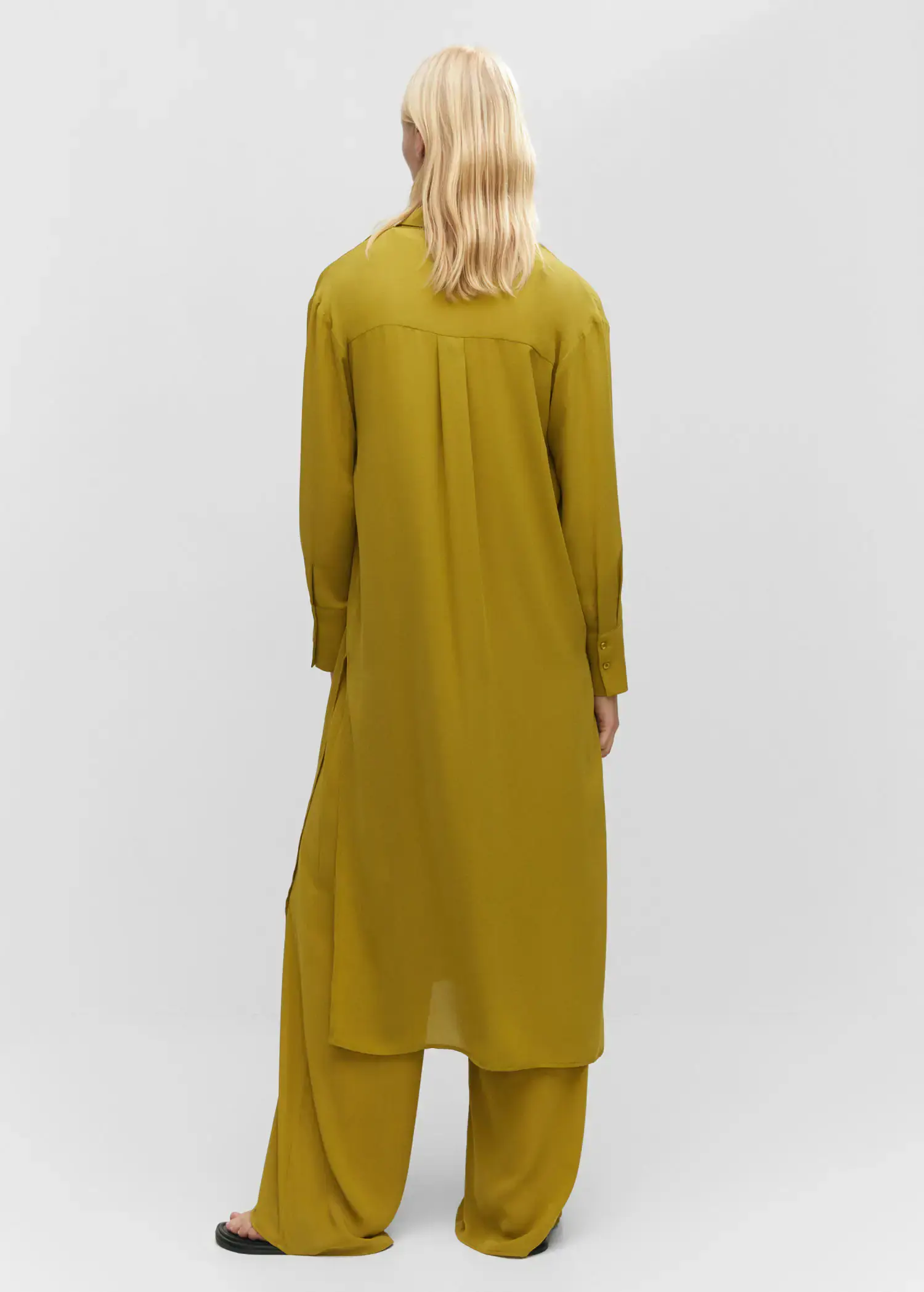 Mango Shirt dress with slits. a person wearing a yellow outfit standing next to a wall. 
