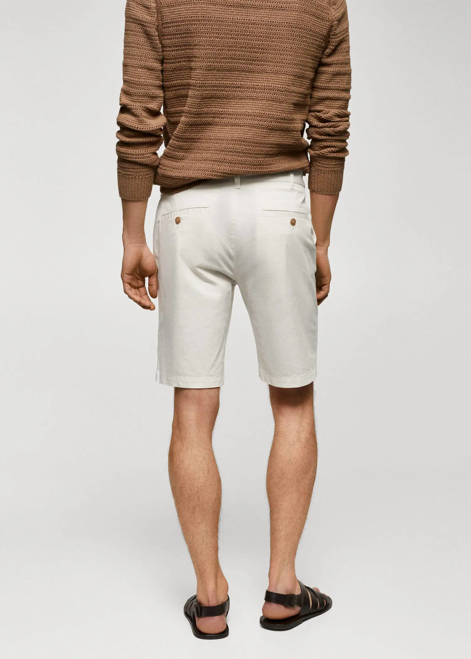 Mango Chino Bermuda shorts. a man wearing white shorts and a brown sweater. 