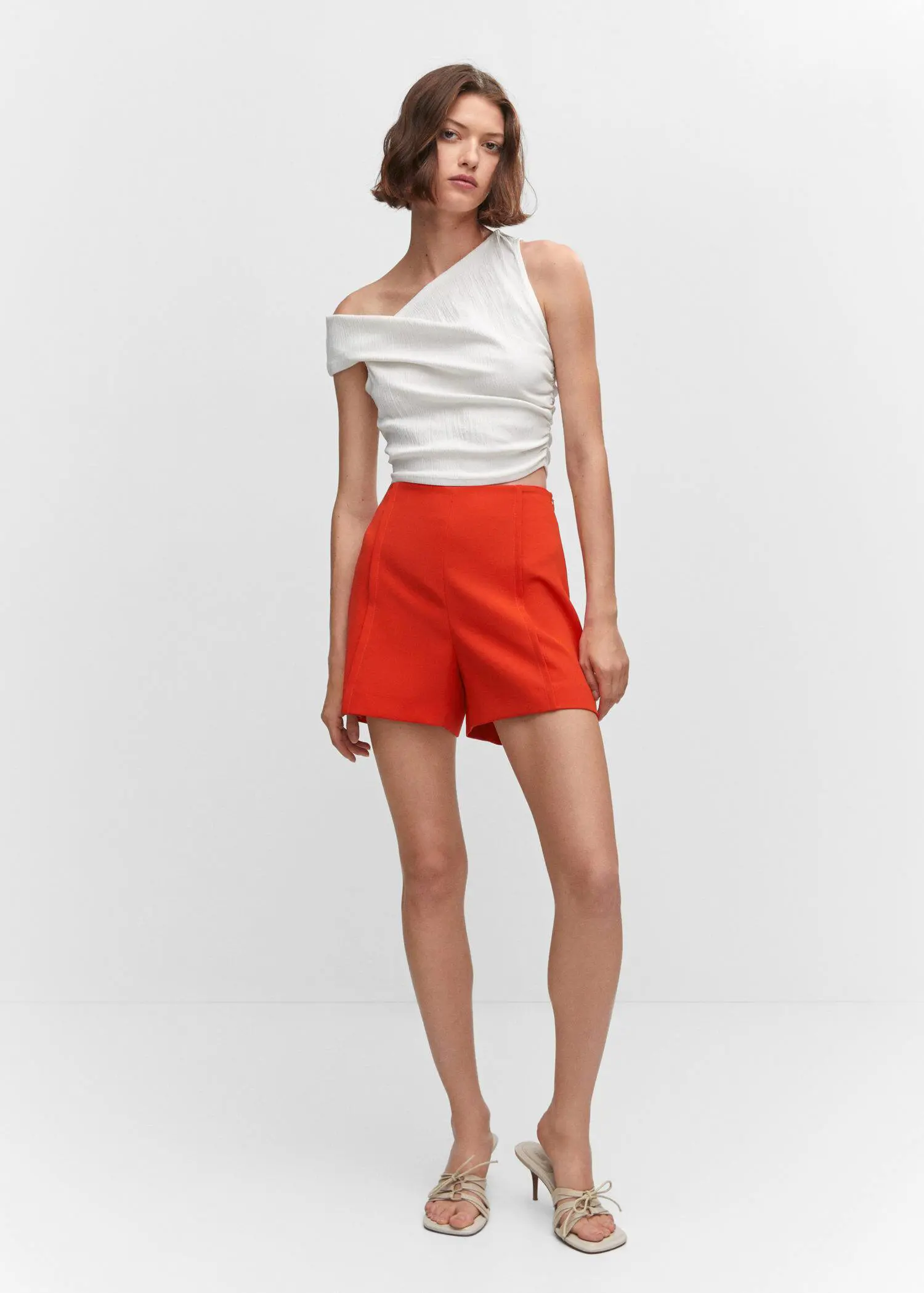 Mango High-waist straight shorts. a woman wearing a white top and red shorts. 