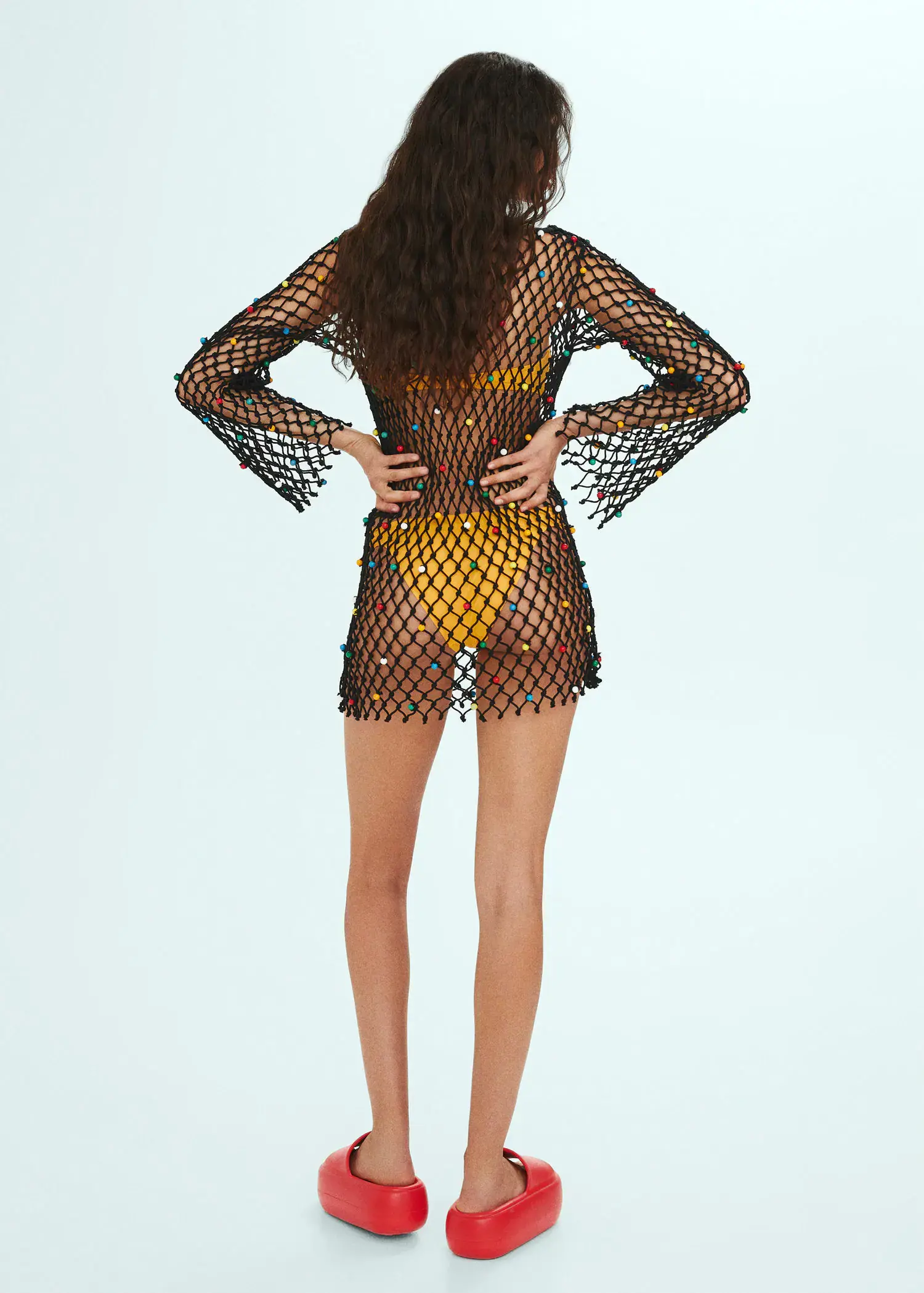Mango Mesh dress with bead detail. a woman in a see-through dress standing with her hands on her hips. 