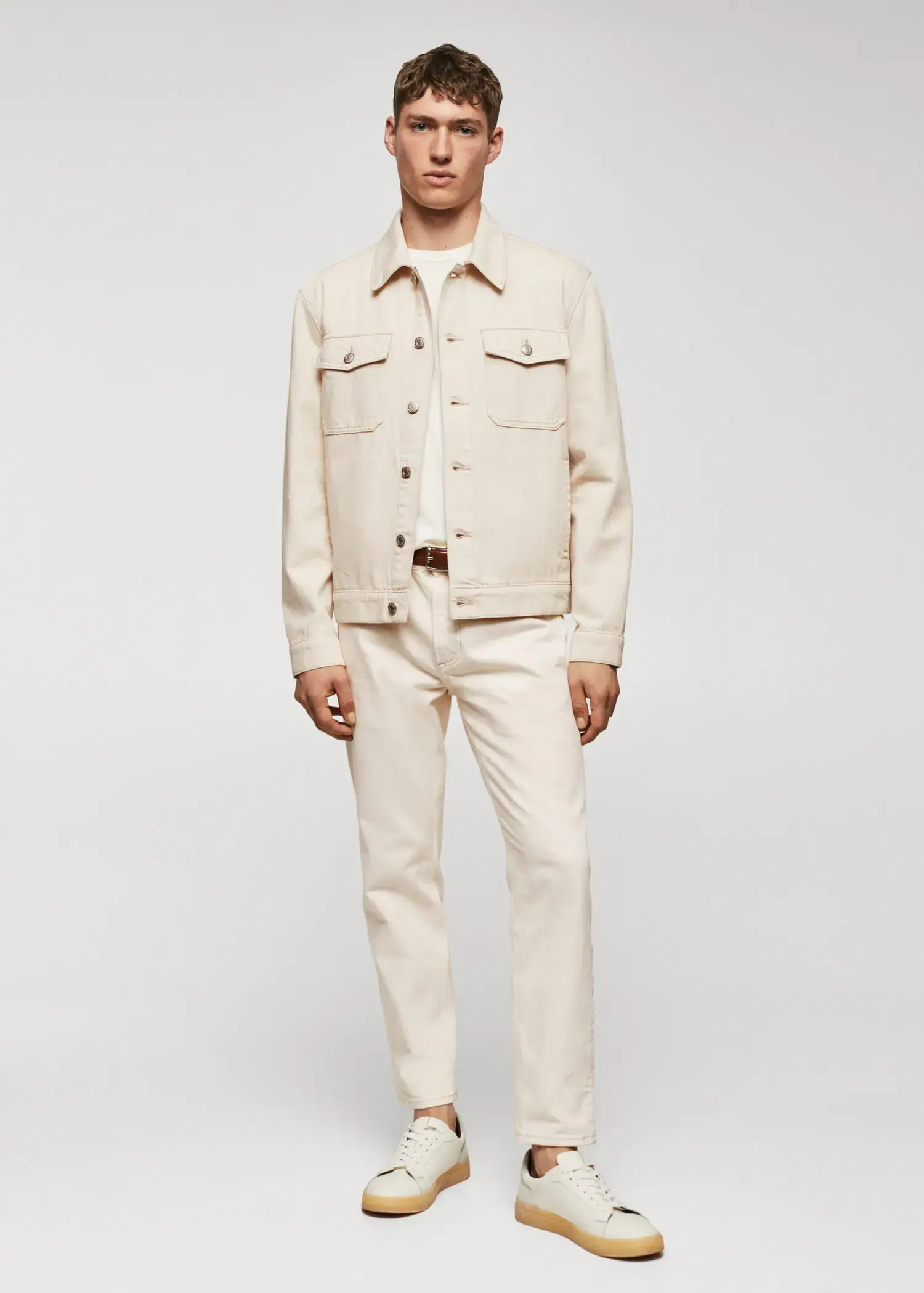 Mango Pocketed denim jacket. a man in a white outfit standing in front of a white wall. 