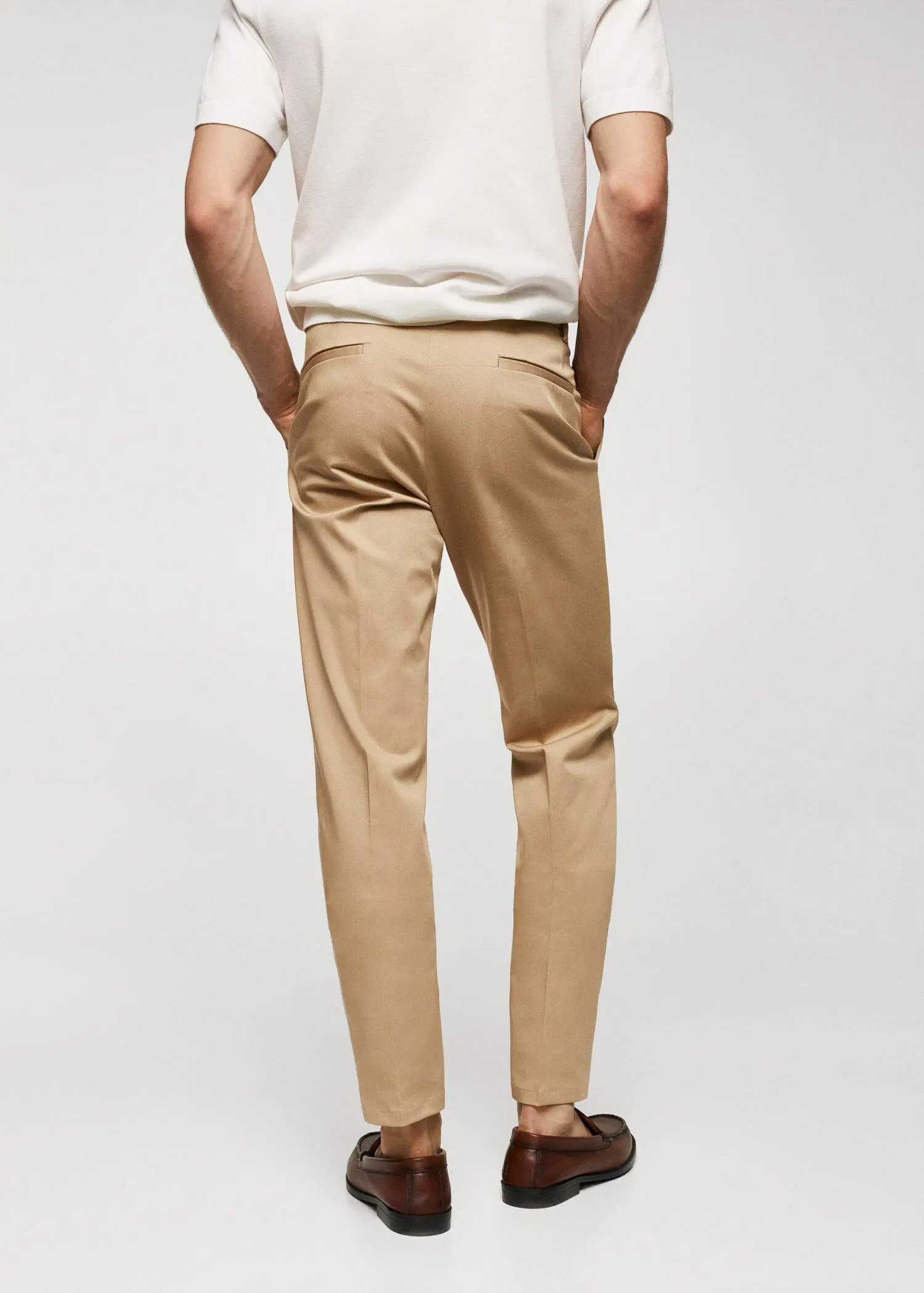 Mango Slim fit chino trousers. a man is standing with his hands in his pockets. 