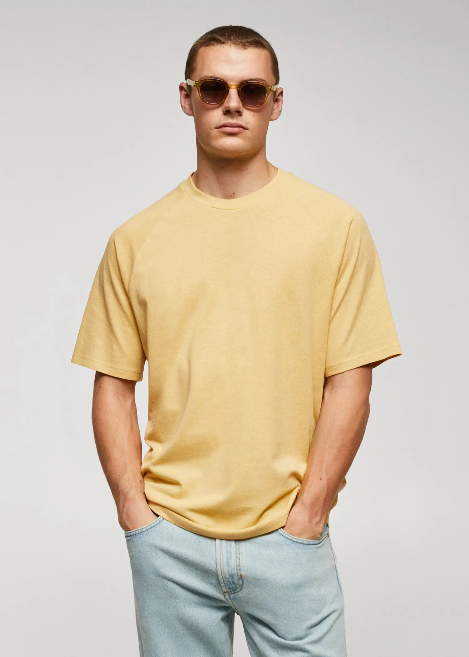 Mango Textured cotton-linen t-shirt. a man wearing a yellow shirt and sunglasses. 