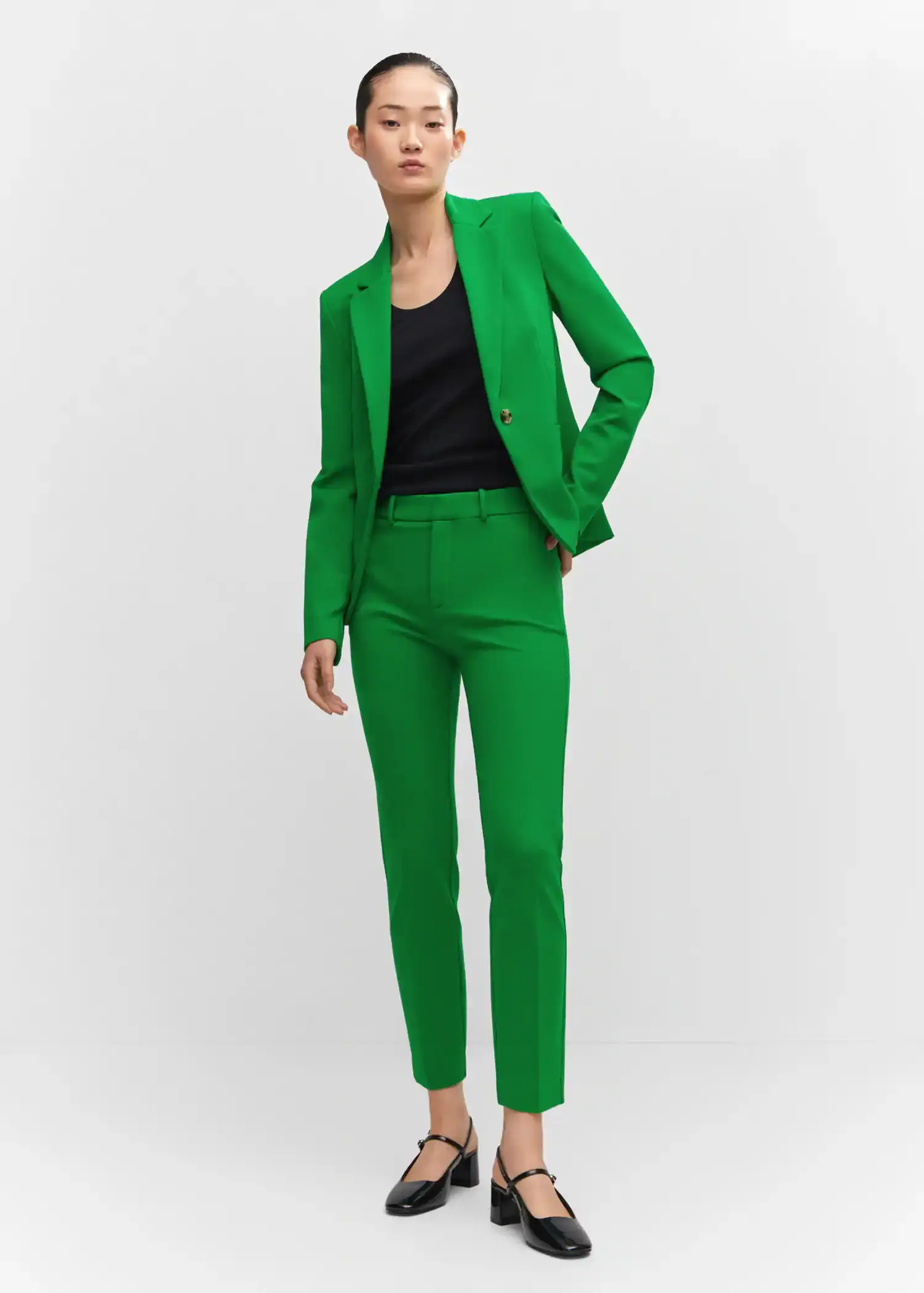 Mango Rome-knit straight pants. a woman wearing a green suit standing in front of a white wall. 