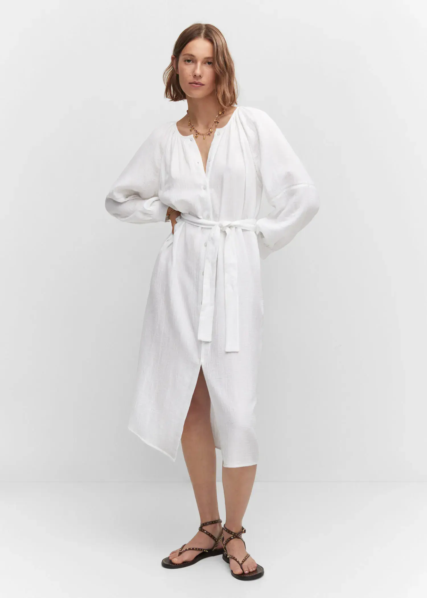 Mango Belt cotton dress. a woman wearing a white dress standing in front of a white wall. 