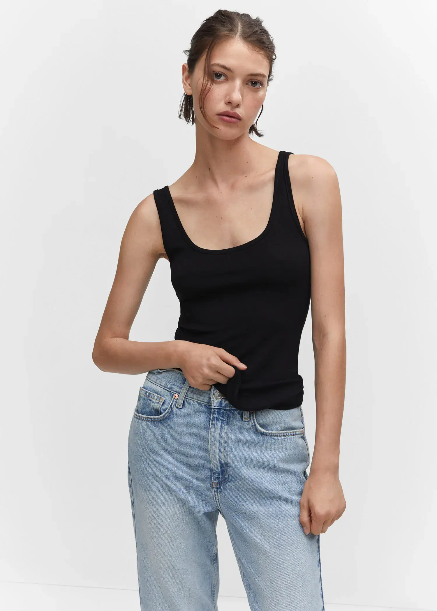 Mango Strapless halter neck top. a woman in black tank top and jeans. 