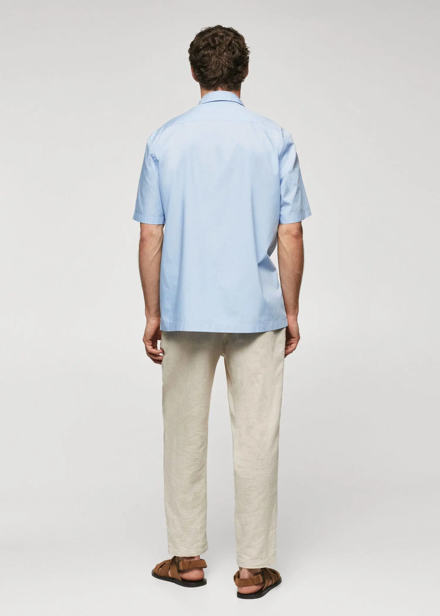 Mango Regular-fit cotton short sleeve shirt. a man wearing a light blue shirt and beige pants. 