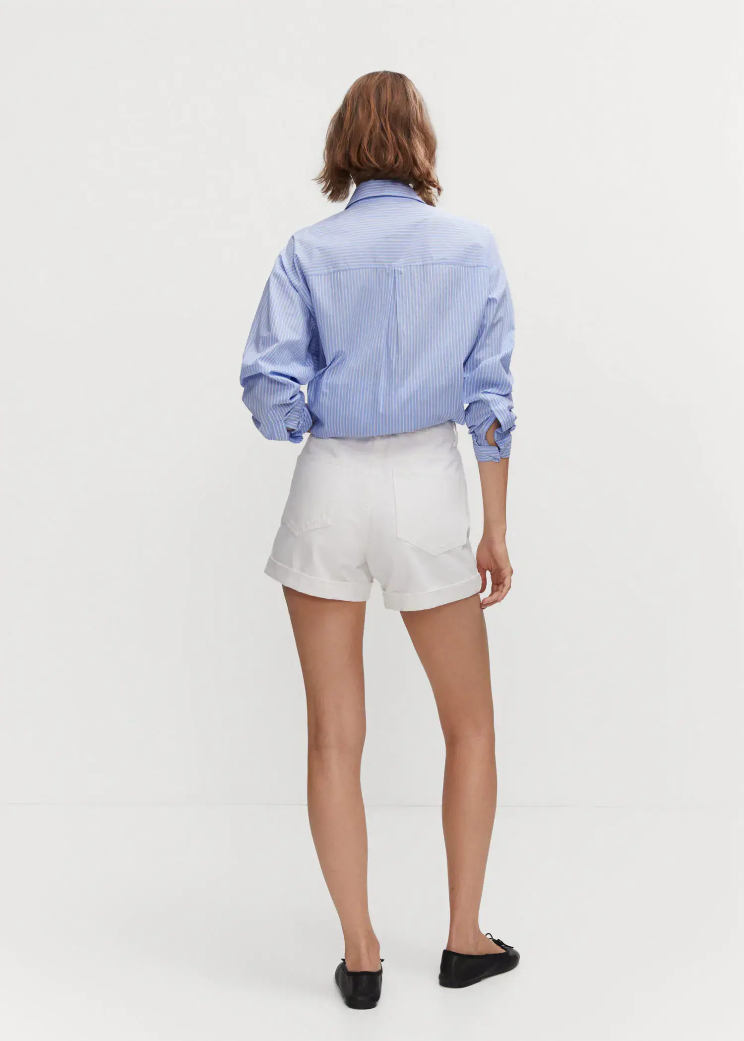 Mango Mom-fit denim shorts. a woman wearing white shorts and a blue shirt. 