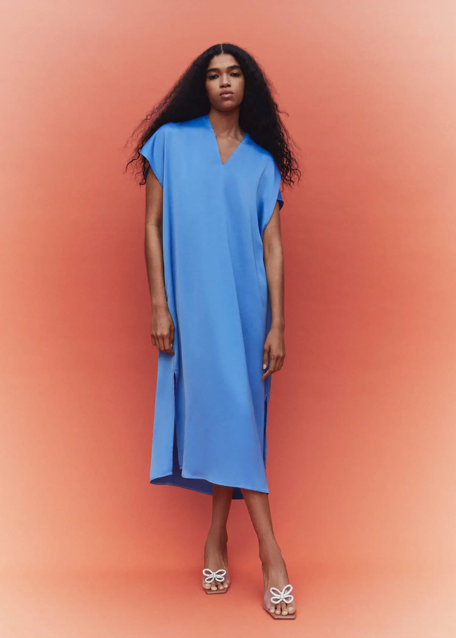 Mango Side slit dress. a woman in a blue dress standing in front of an orange background. 