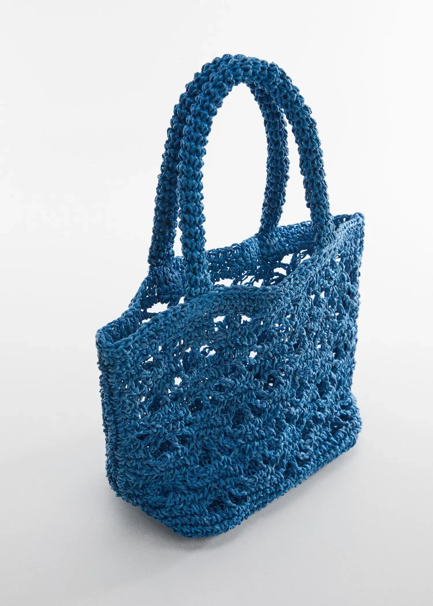 Mango Double-handle raffia bag. a crocheted bag is shown on top of a table. 