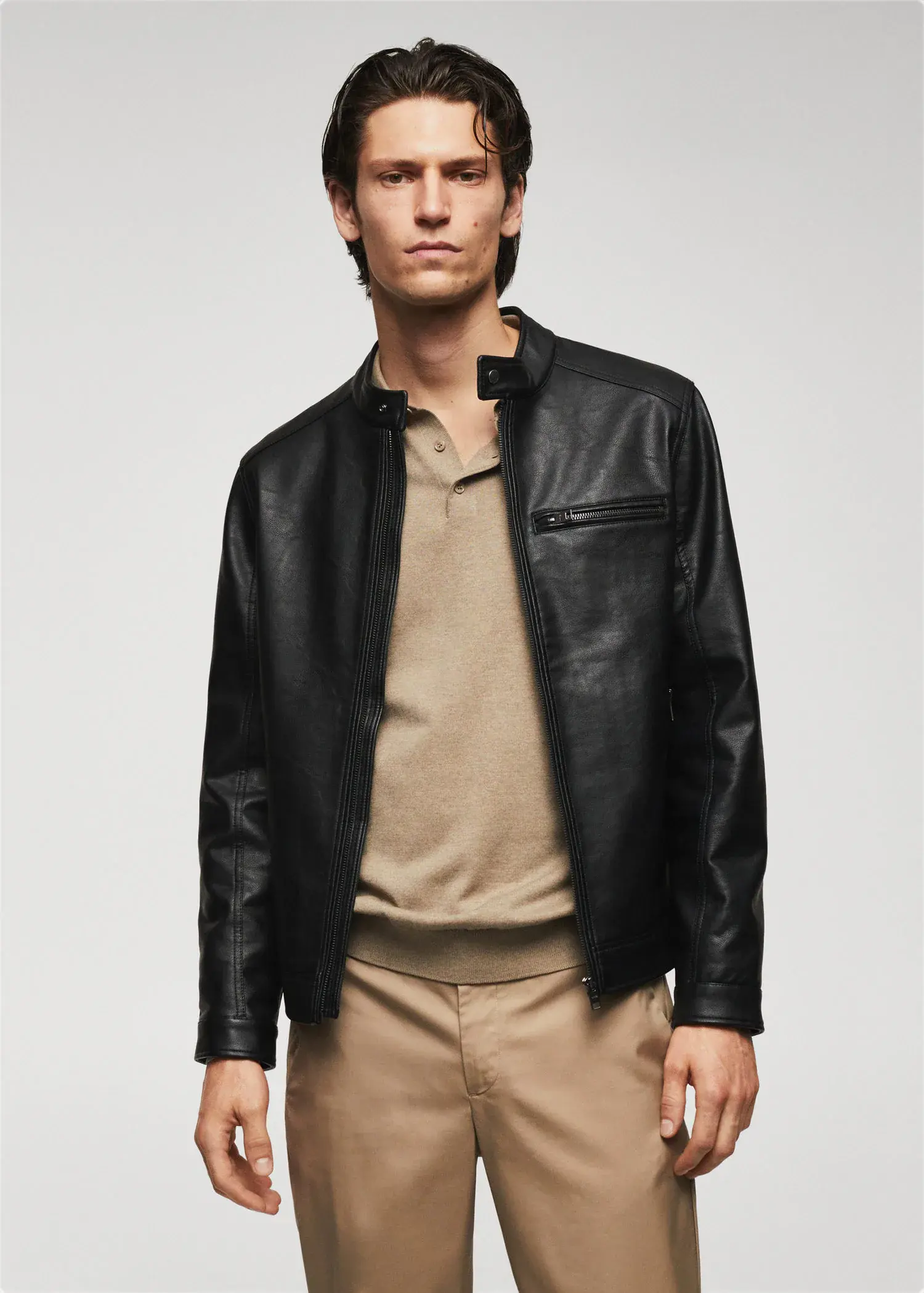 Mango Leather-effect jacket with zips. a man wearing a black leather jacket and beige pants. 