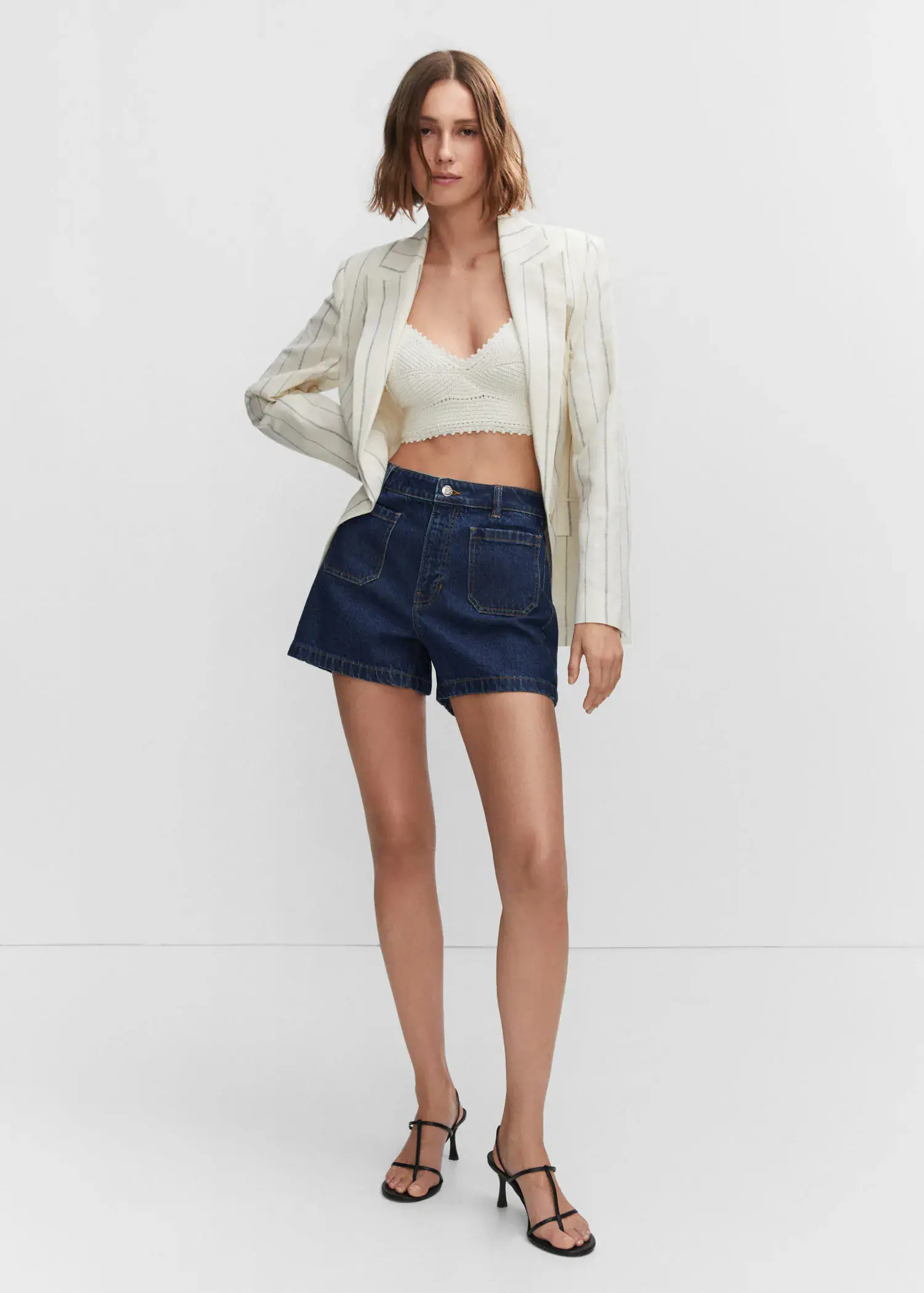 Mango Denim shorts with pockets. a woman in a white jacket and blue shorts. 