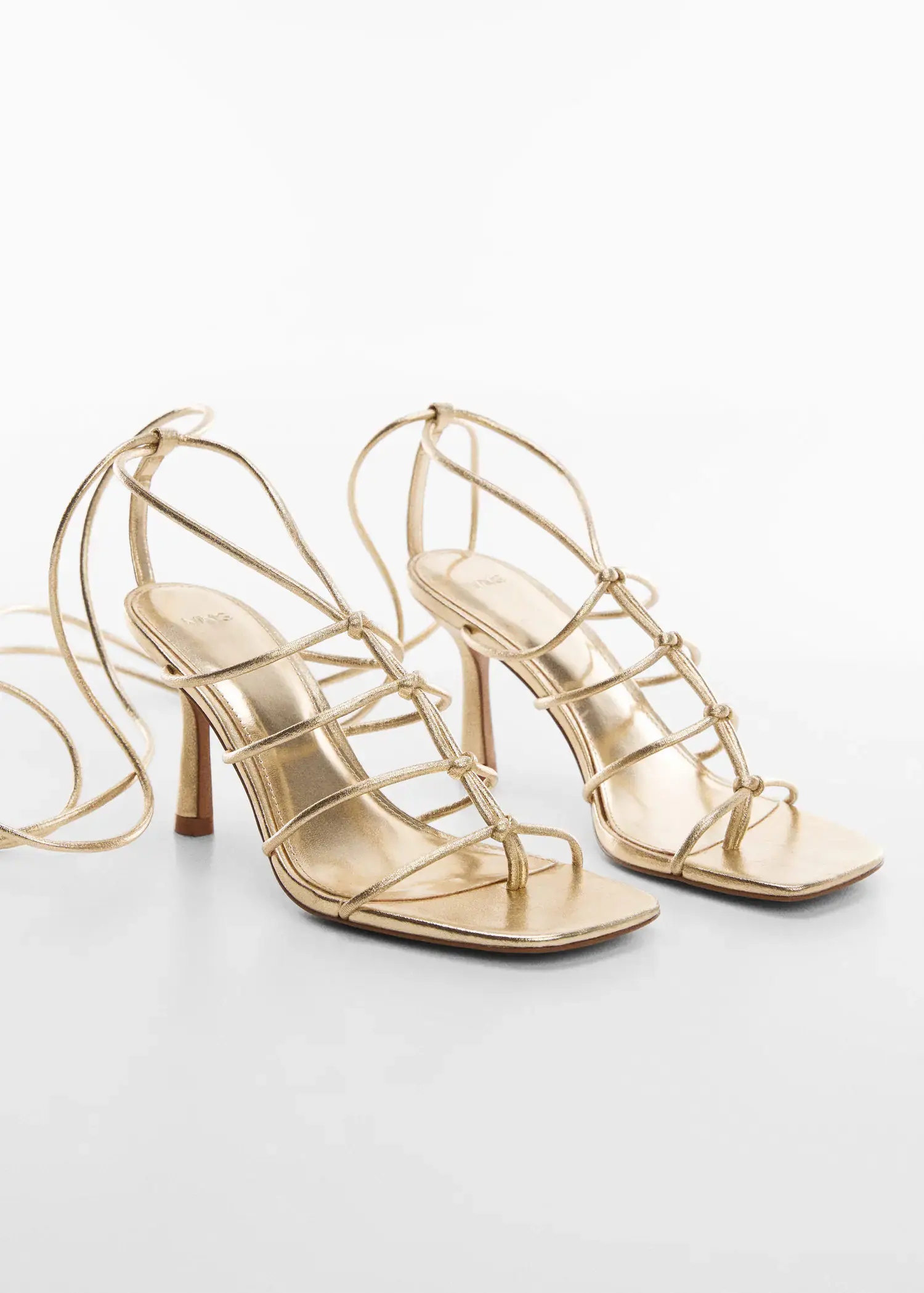 Mango Metallic strappy heeled sandal. a close up of a pair of high heel shoes 