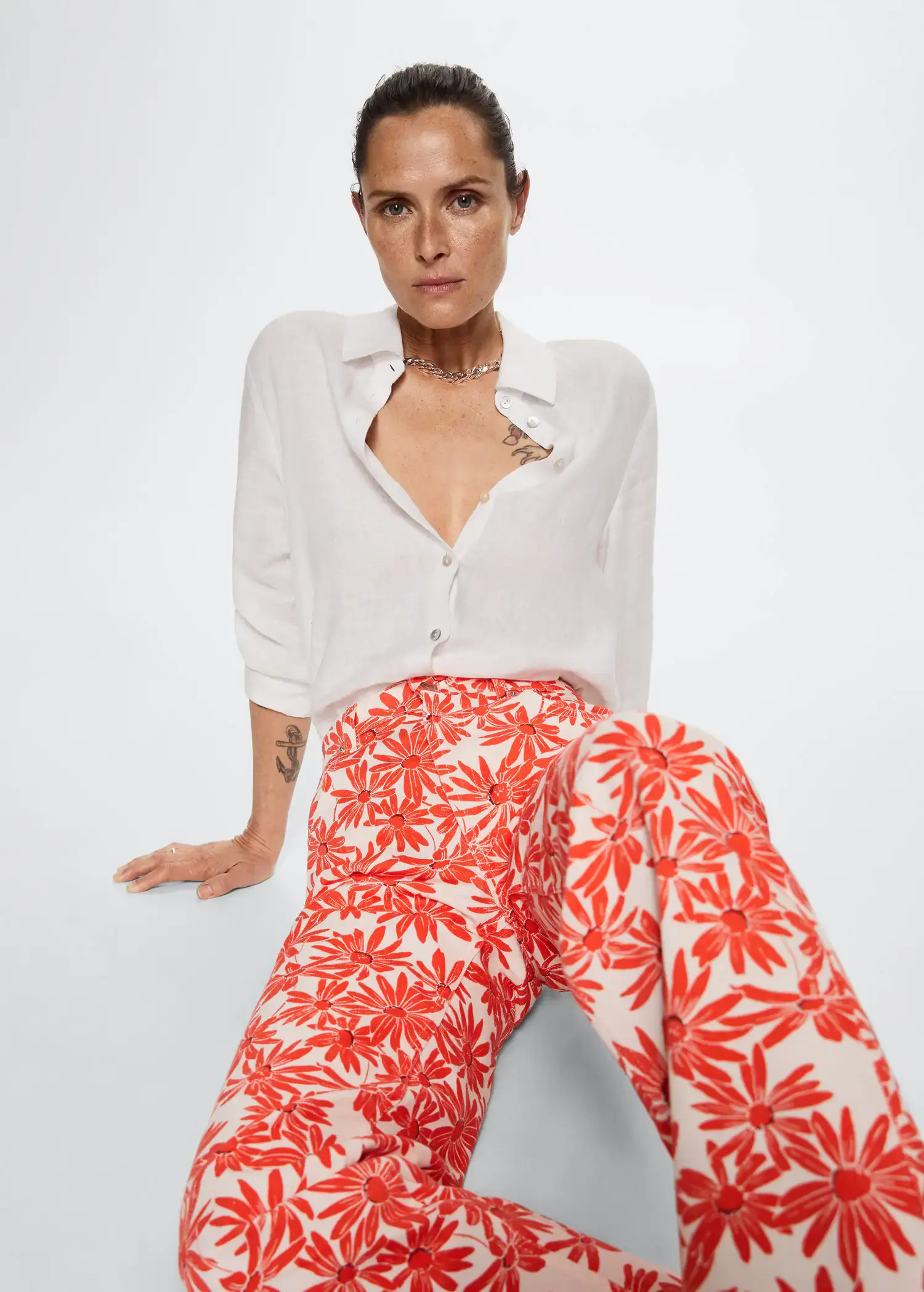 Mango Printed straight jeans. a woman sitting on the ground wearing a white shirt. 